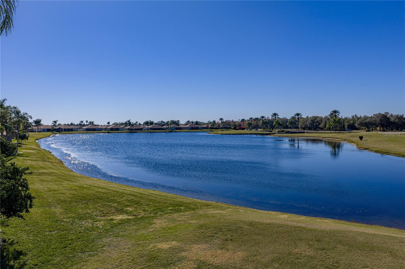 The pond behind this home is the water hazard for the 11th hole. The island green for this dog leg par 4 is in the background. - 4360 ASHTON CLUB DR, LAKE WALES