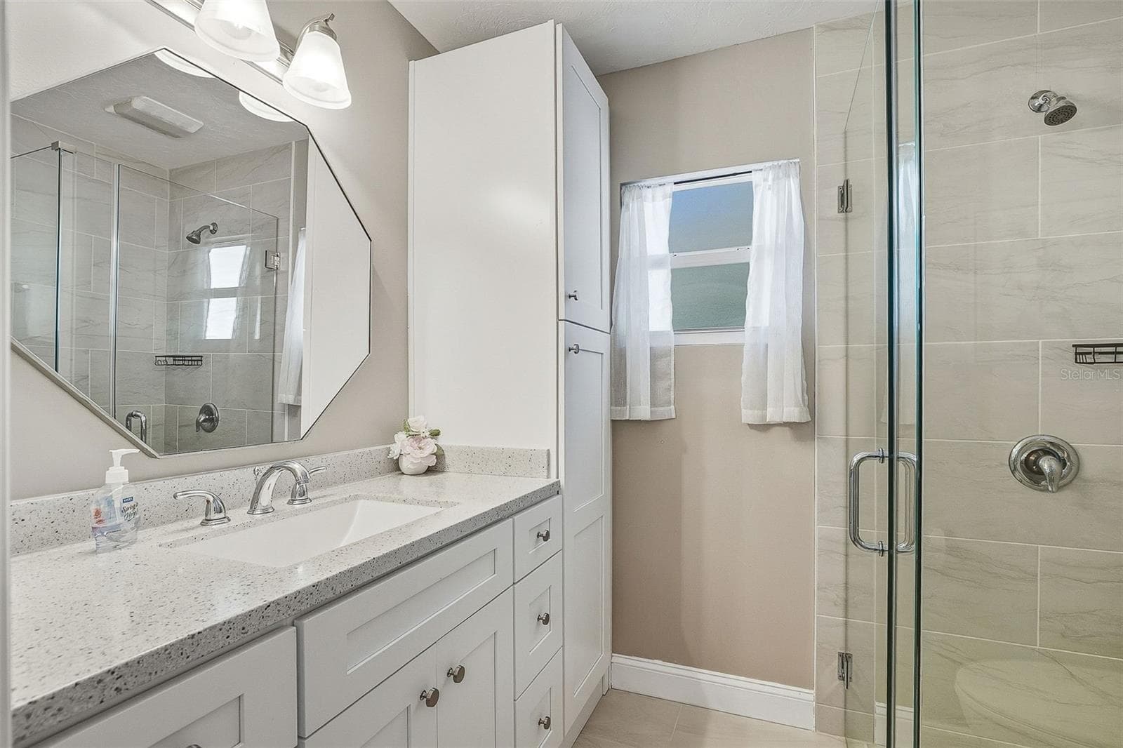Updated primary ensuite full bath offers tiled stand-alone shower and linen closet for added storage. - 6300 MIDNIGHT PASS RD #21, SARASOTA