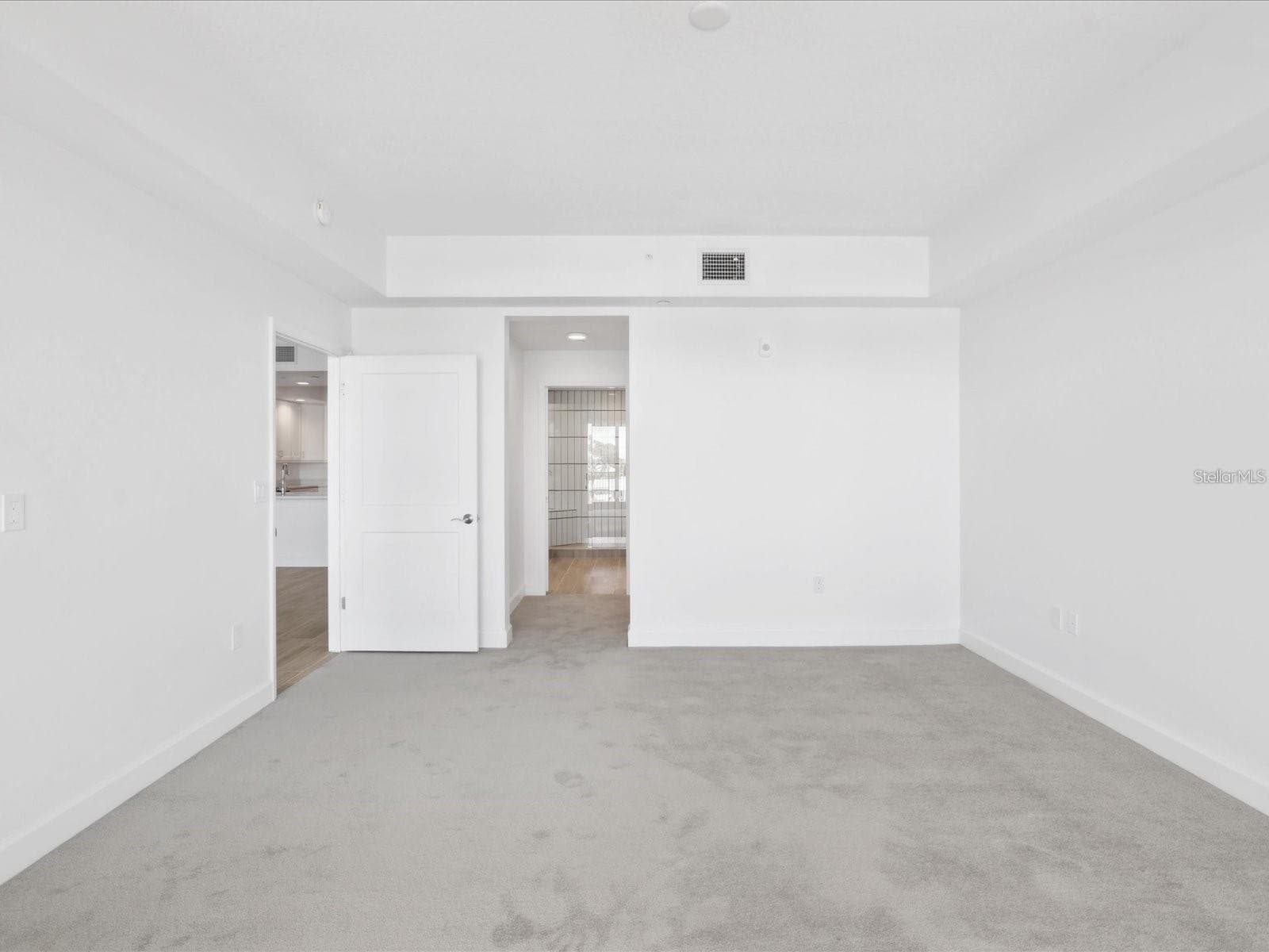 Primary bedroom looking to hall to private bath - 125 ISLAND WAY #304, CLEARWATER BEACH