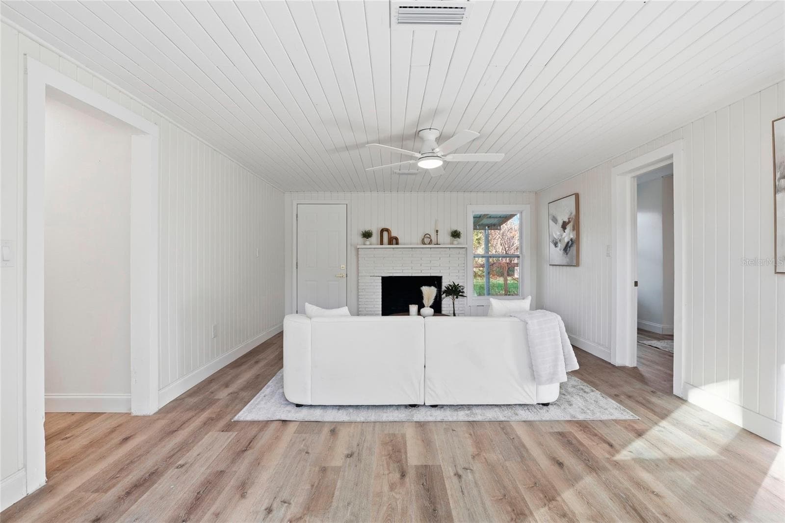 Spacious family room with vaulted beadboard ceiling and decorative fireplace - 425 SE 2ND ST, WILLISTON