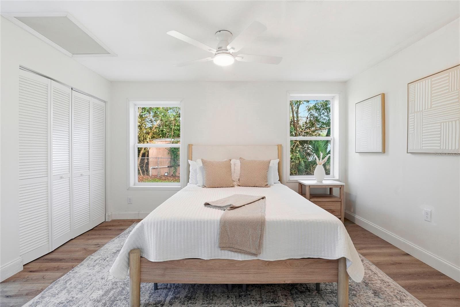 Primary bedroom with new flooring, ceiling fan and two windows - 425 SE 2ND ST, WILLISTON
