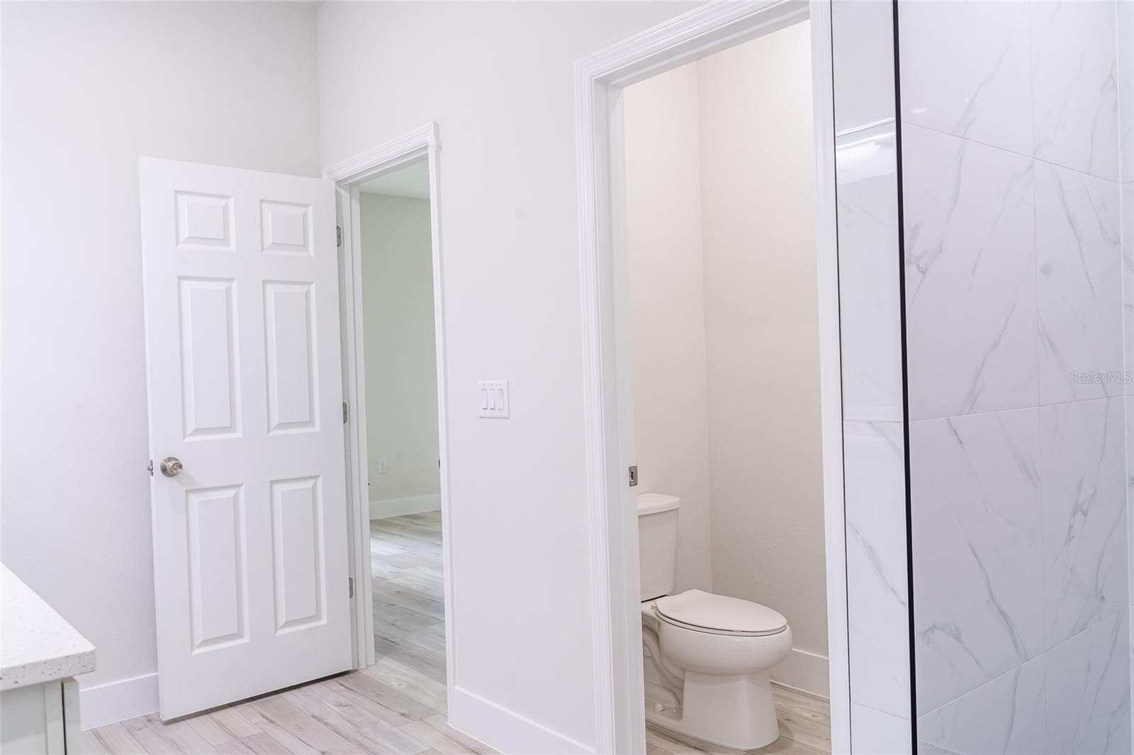 Looking into the separate toilet room from primary bathroom shower - 10955 N DRAGONIS DR, CITRUS SPRINGS