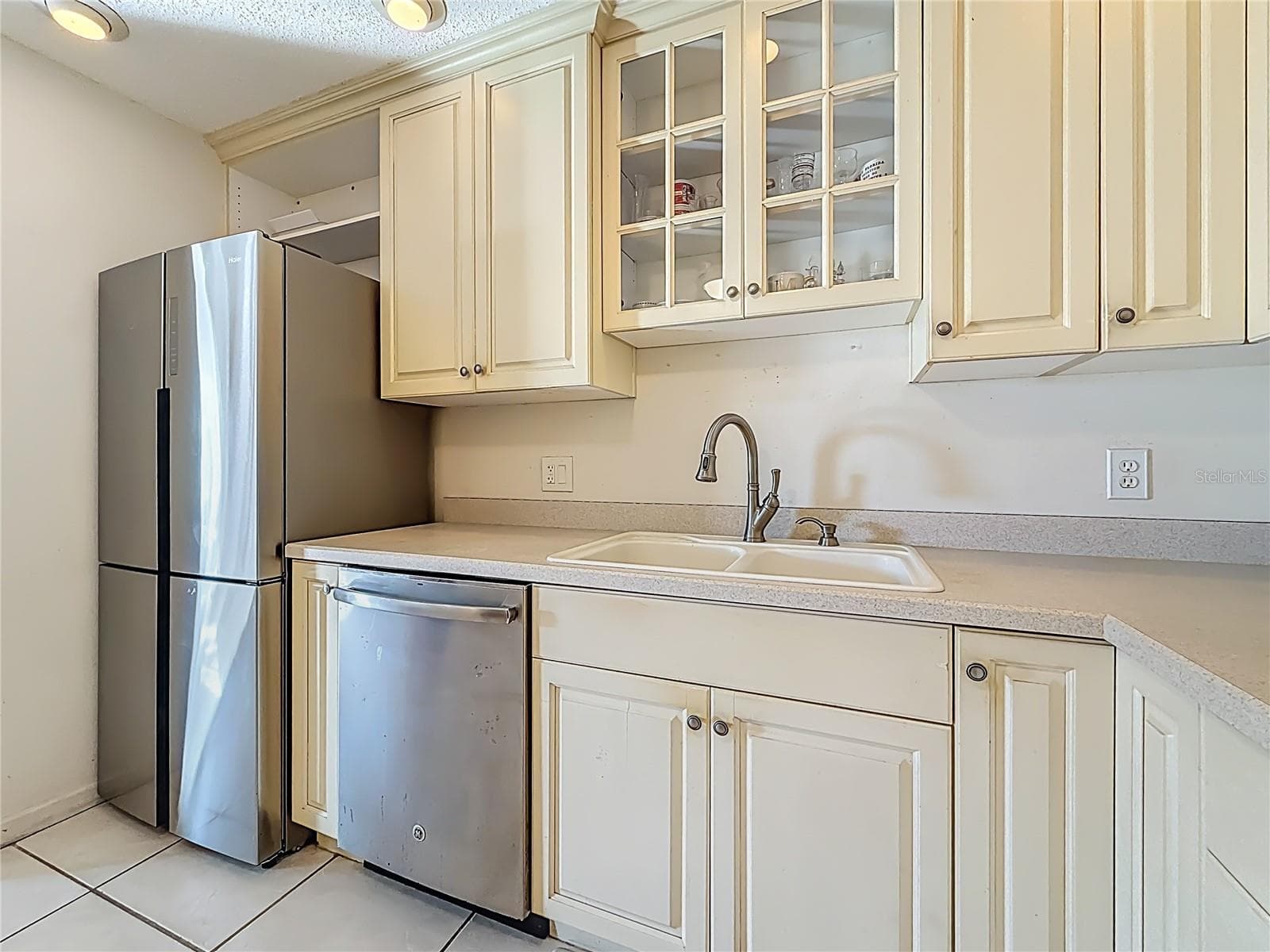 1020 85th Ave N no 119, Kitchen, glass front cabinets over sink - 1020 85TH AVE N #119, ST PETERSBURG