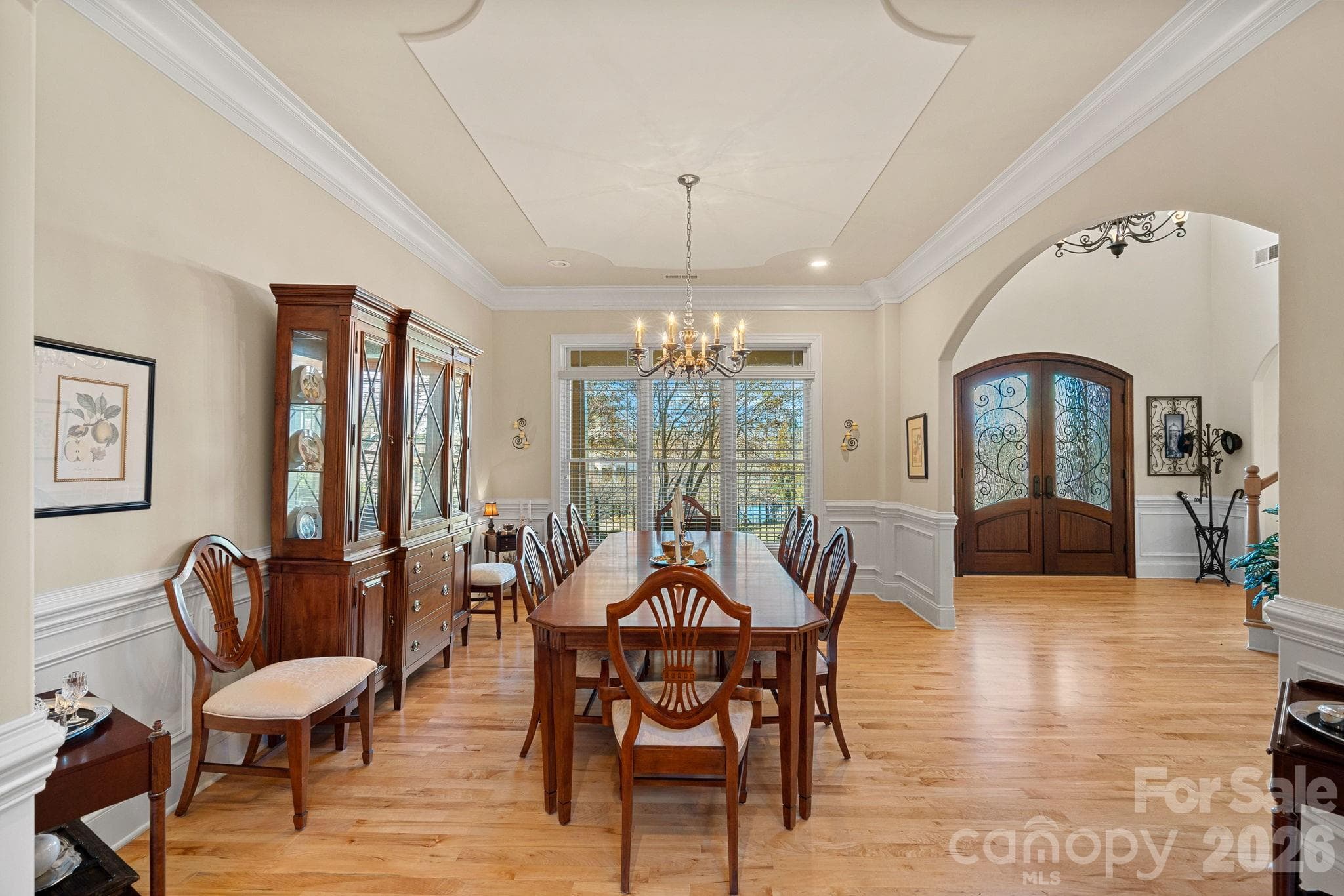 Elegant dining room with custom tray ceiling, crown molding, and wainscoting. - Denver