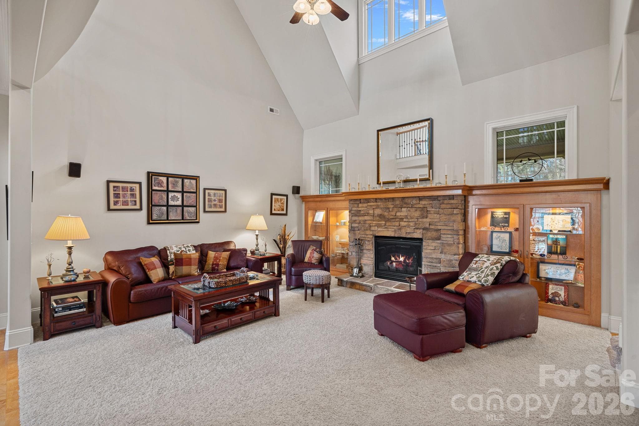 Spacious living room with vaulted ceilings, stone fireplace, and custom built-ins. - Denver