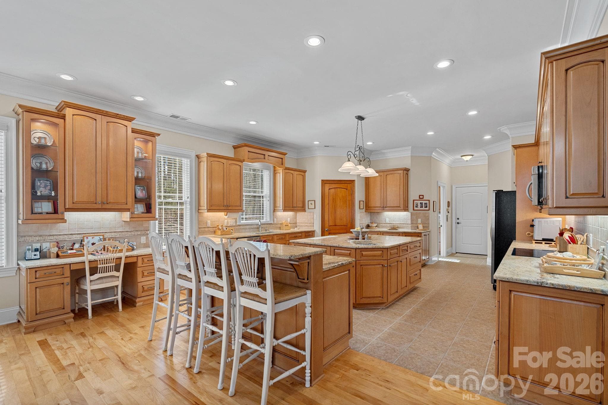 Thoughtfully designed eat-in kitchen featuring counter seating, a large island with secondary prep sink, double ovens, abundant cabinetry and counter space, walk-in pantry, and a built-in desk/work station. - Denver