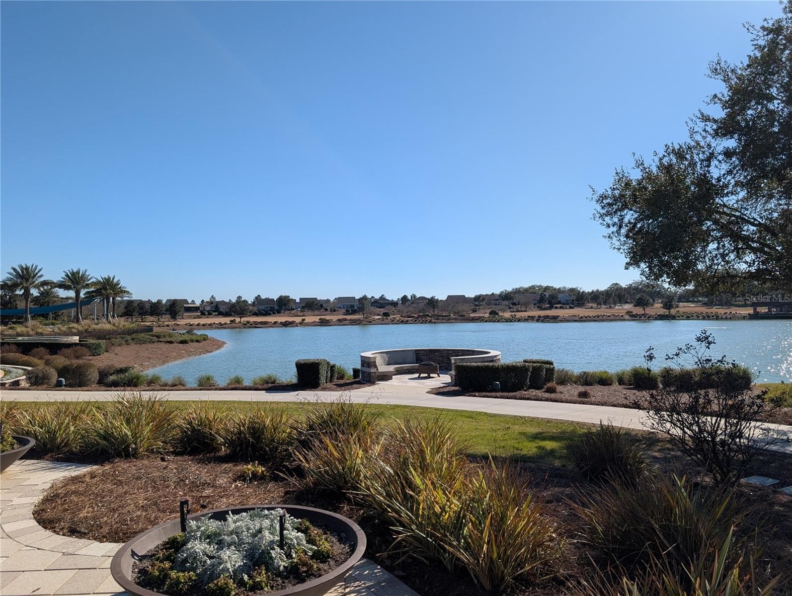 Back Patio of Clubhouse looking at fire Pit by Lake - 4341 NW 57TH AVE, OCALA