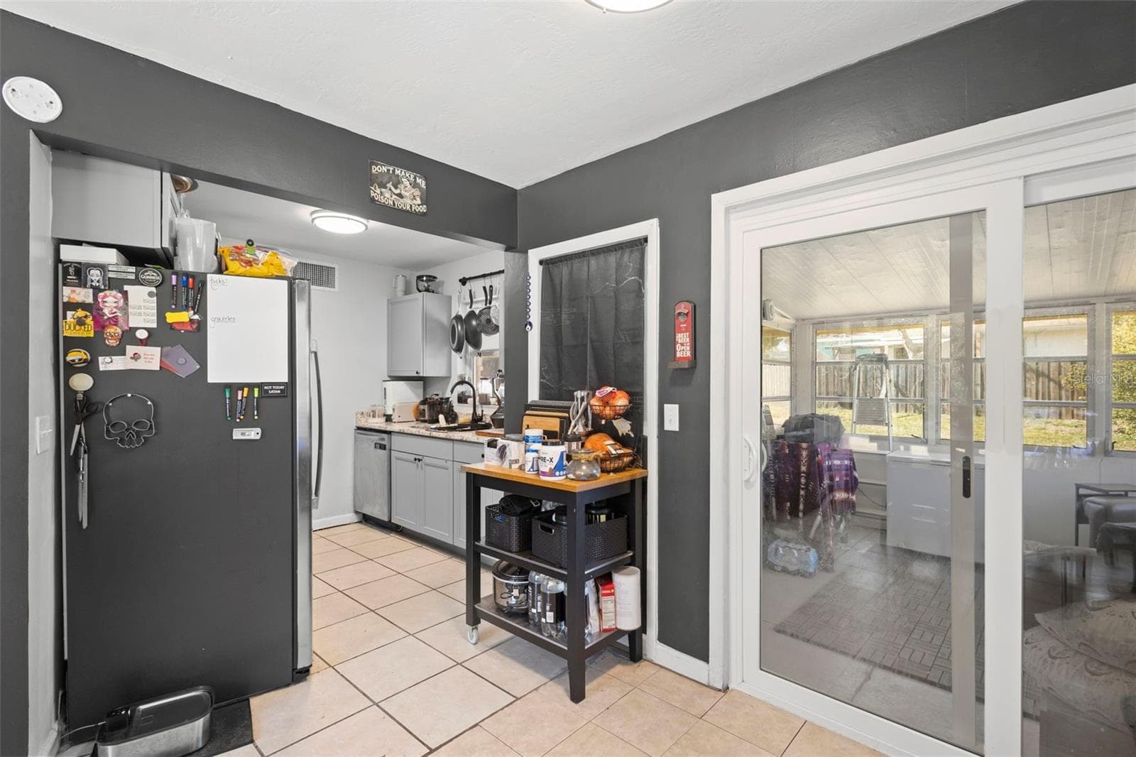 View from dining area toward kitchen and patio with new french doors. - 1552 ZINNIA DR, DELTONA