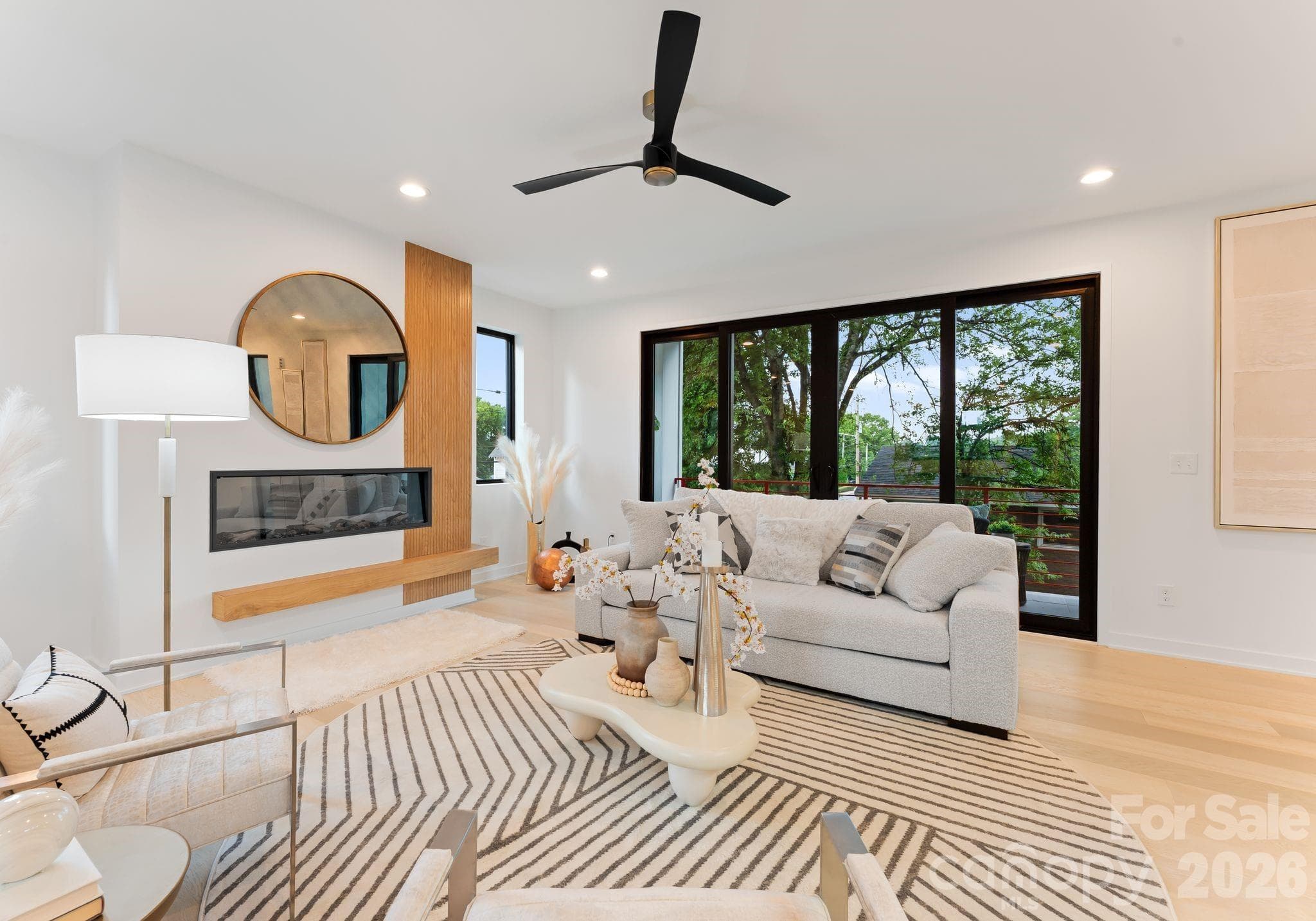 Open living area with electric fireplace. - Charlotte