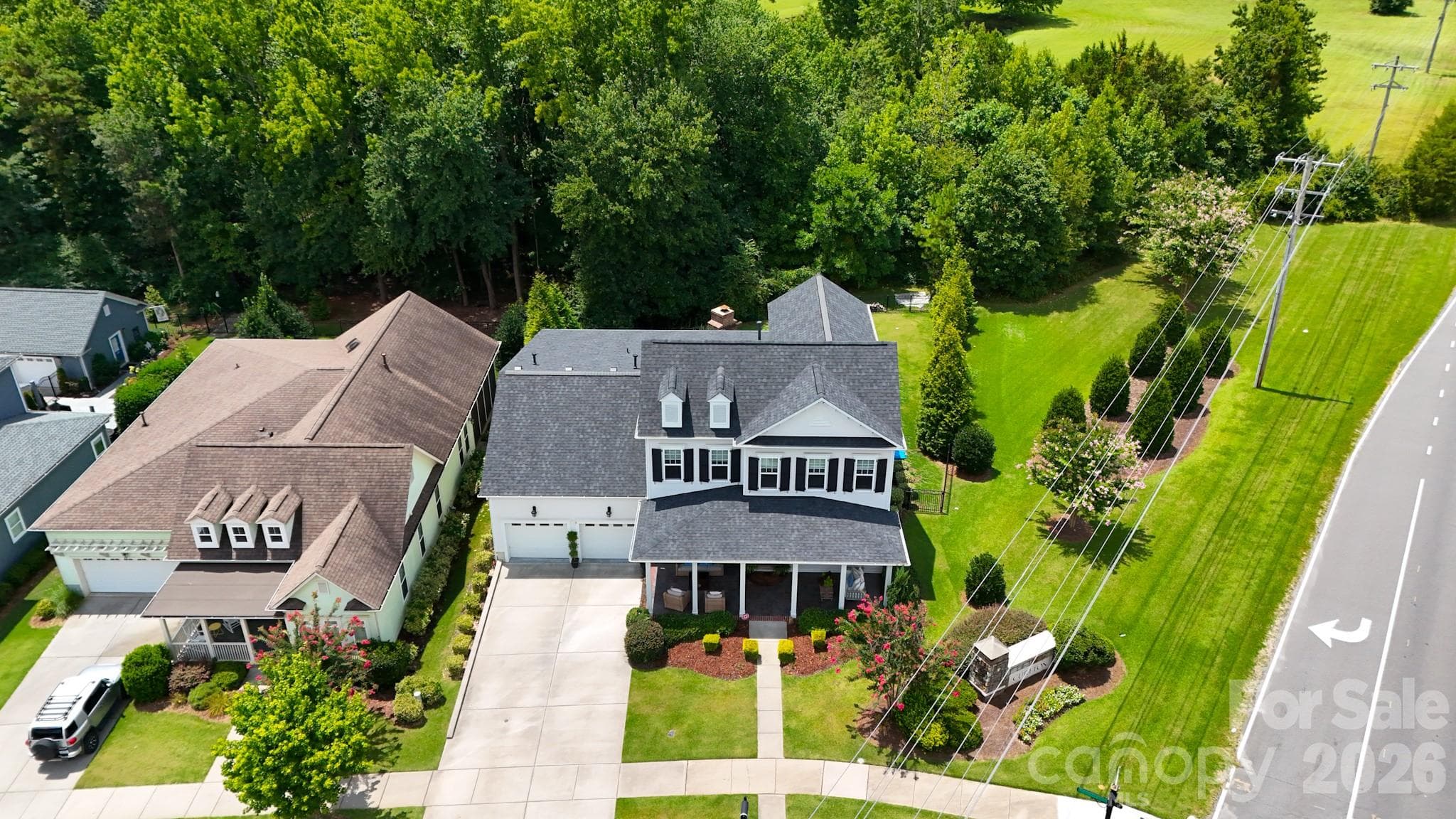 Private, fenced backyard retreat backing up to lush woods, featuring a tucked-away brick outdoor fireplace. - 2702 Arsdale Road, Waxhaw