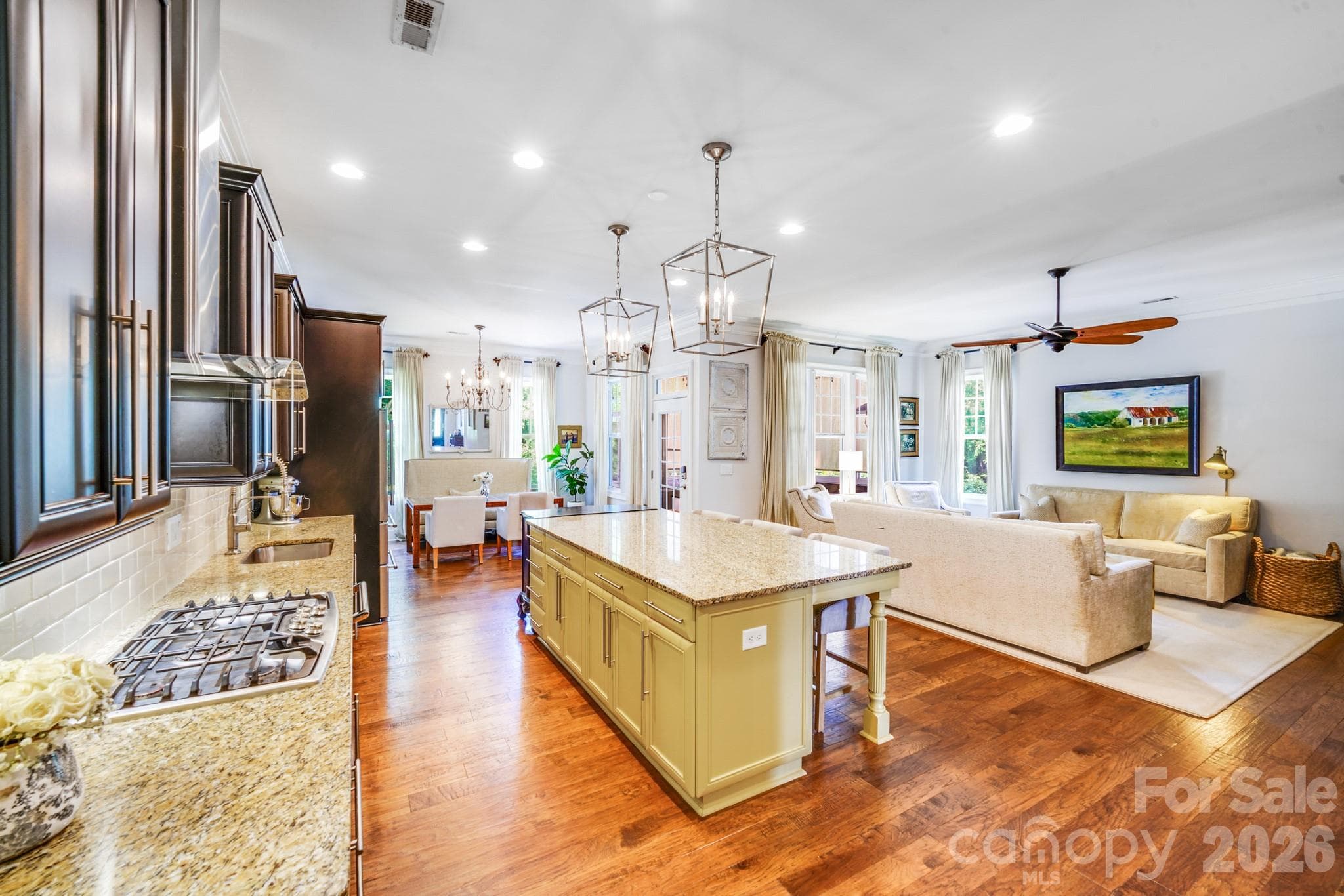 Expansive granite island with ample seating, painted in a cheerful golden yellow for a designer pop of color - 2702 Arsdale Road, Waxhaw