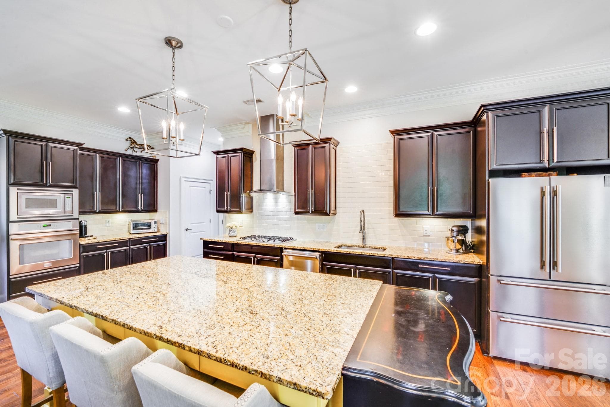Kitchen boasts custom espresso cabinetry with oversized brushed hardware and under-cabinet lighting for added warmth and functionality - 2702 Arsdale Road, Waxhaw