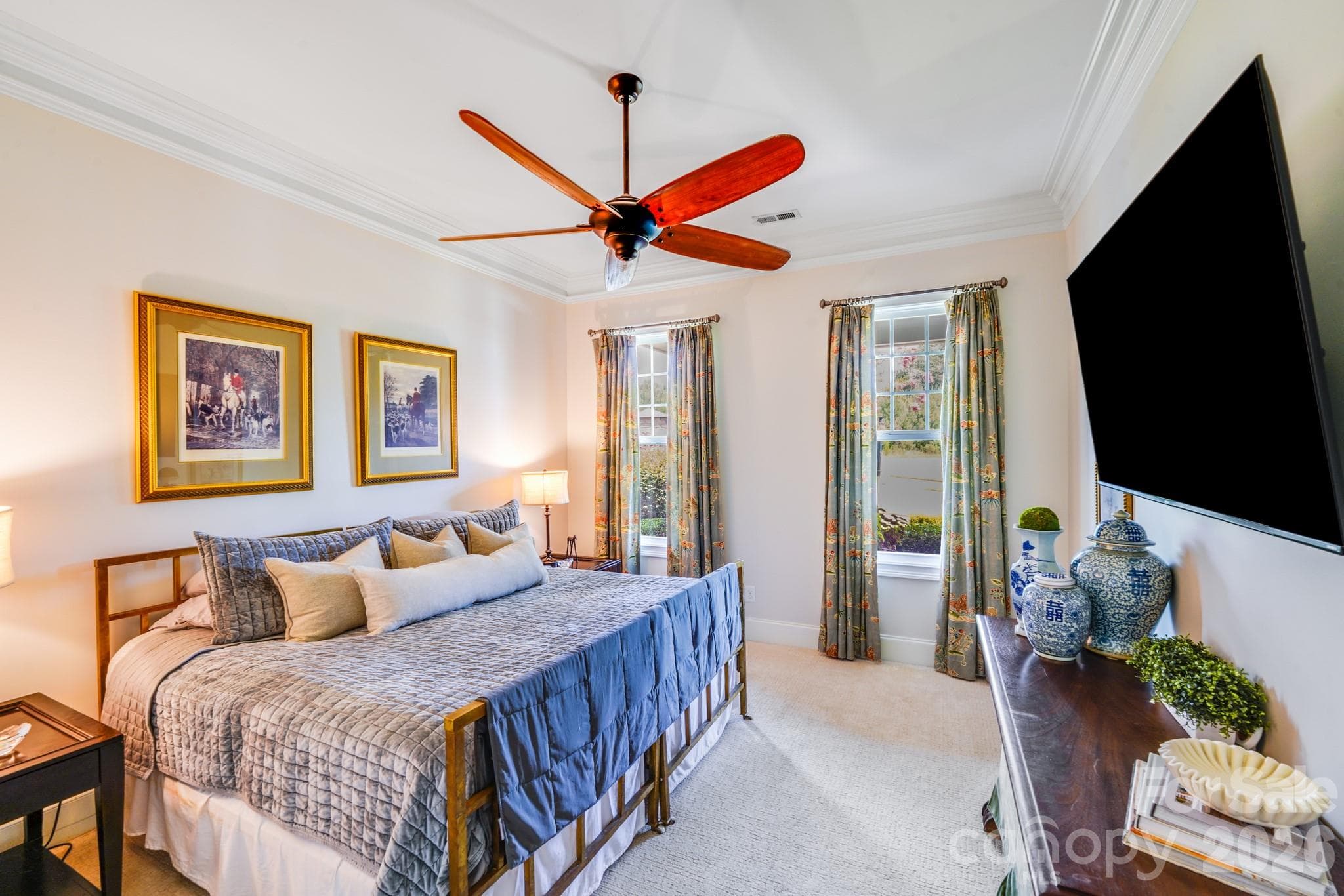 Plush carpet, blackout drapes, ceiling fan, and wall-mounted TV create a cozy, guest-ready retreat. - 2702 Arsdale Road, Waxhaw