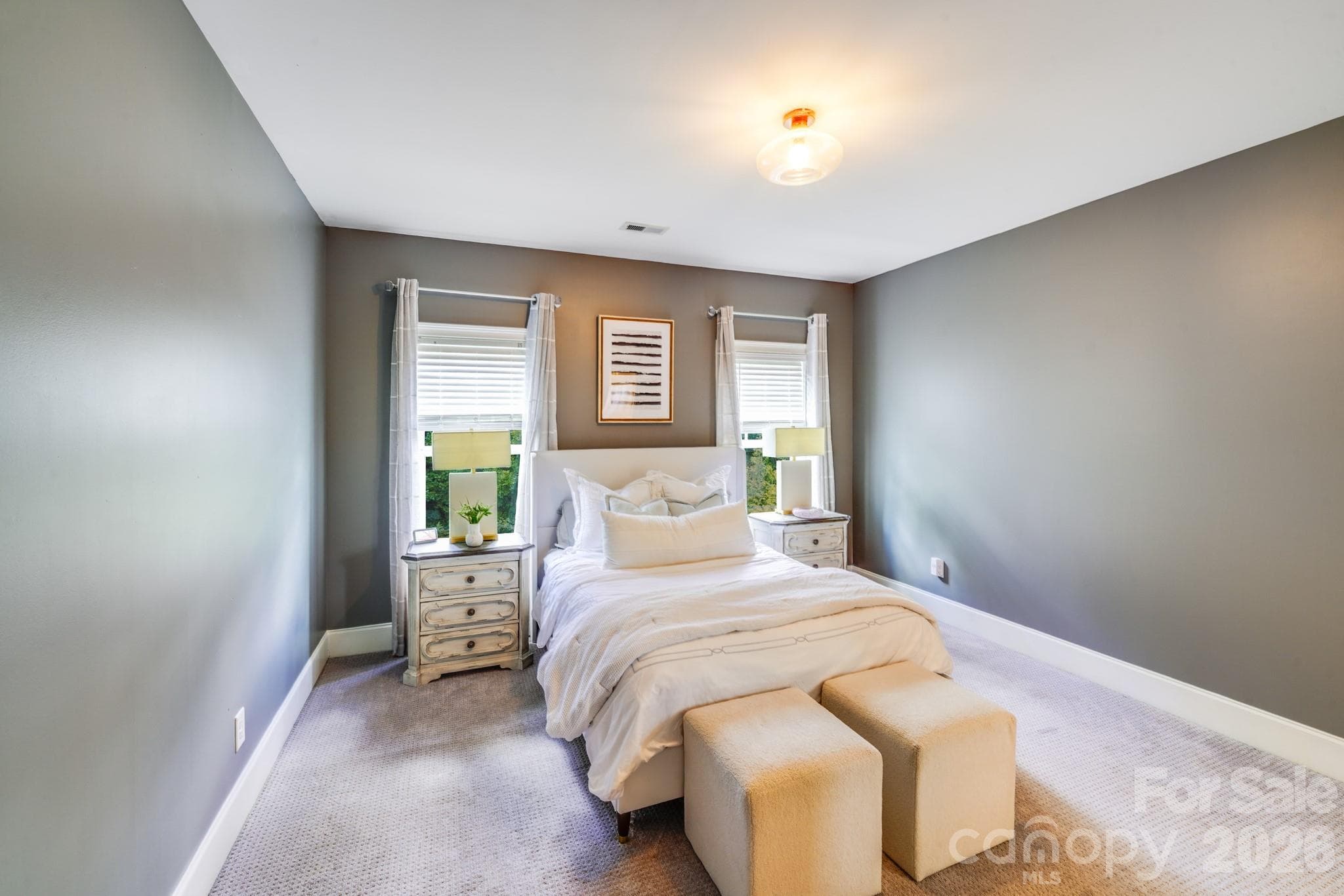 This inviting secondary bedroom features plush carpeting, soft neutral tones, and double windows that fill the space with natural light - 2702 Arsdale Road, Waxhaw