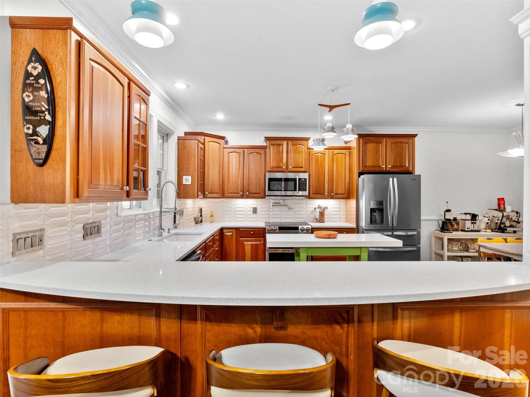 The kitchen's generous countertop provides plenty of seating, creating a comfortable spot for morning coffee, homework, or lively conversation while cooking - Asheville