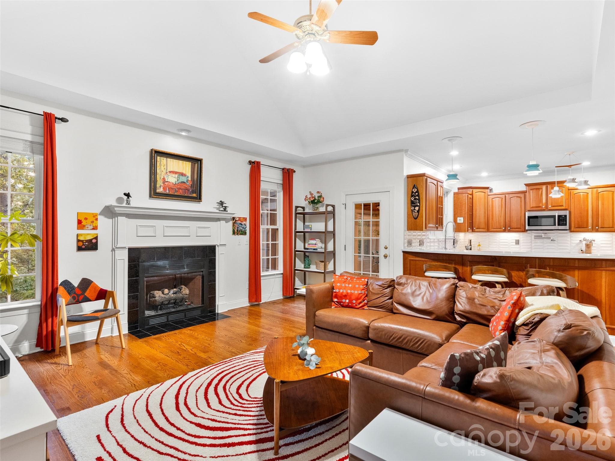 An open-concept family room with access to the sunroom and views into the kitchen provides a functional and inviting layout for family gatherings and entertaining. - Asheville