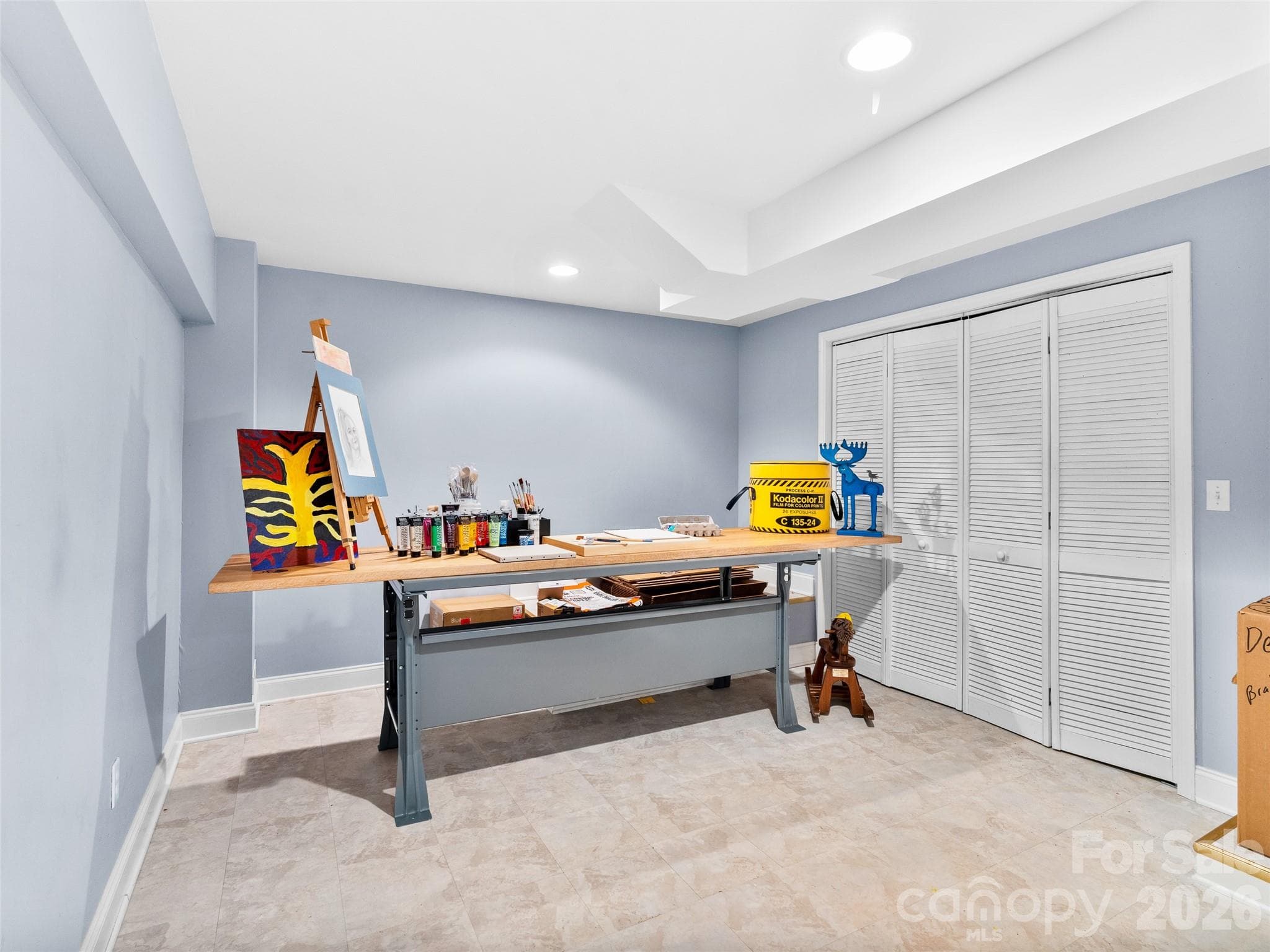 This versatile lower-level craft room offers easy access to a utility closet for storage, conveniently located just off the main lower level living space, making organization and creativity effortless. - Asheville