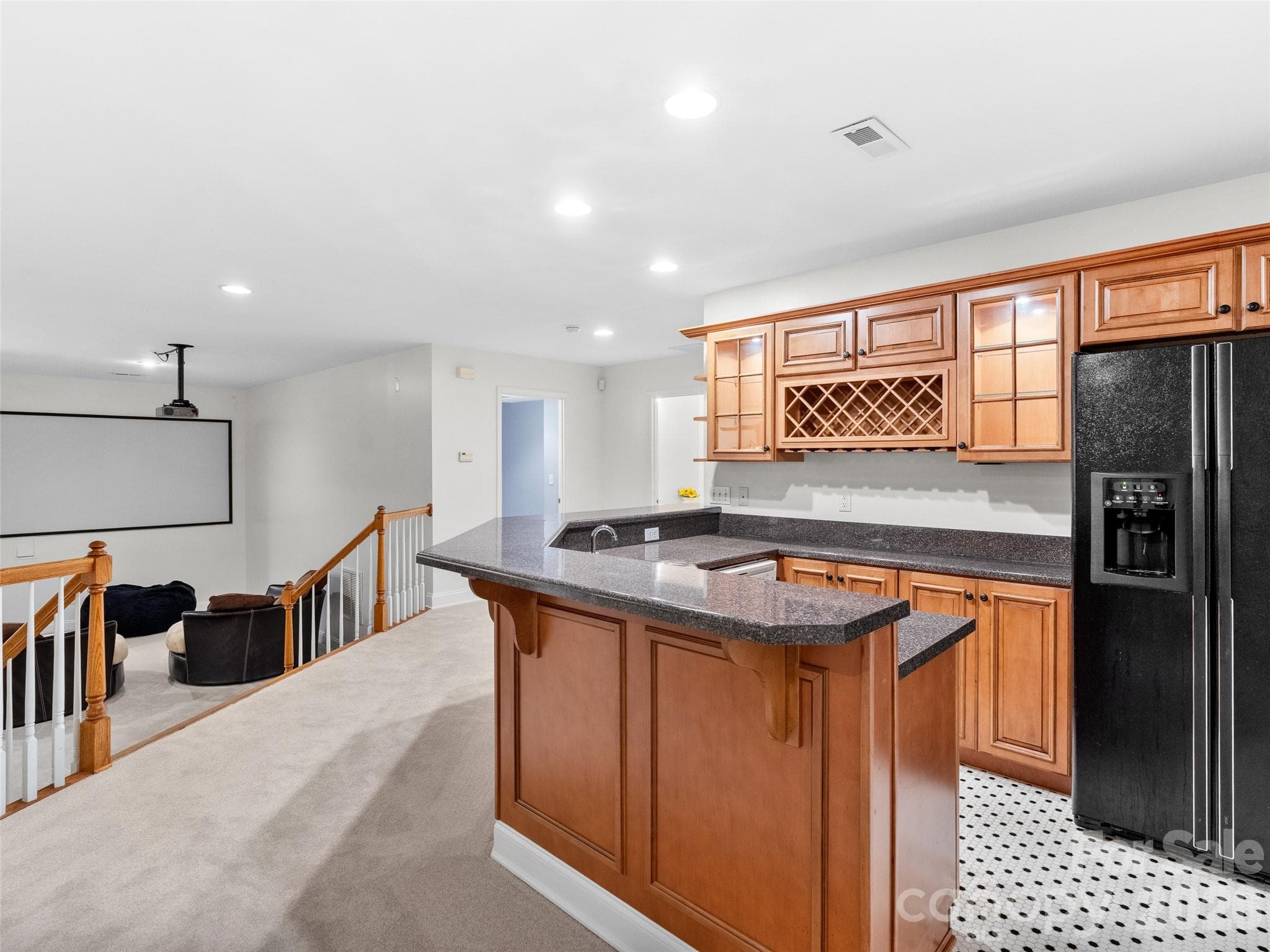 Designed for convenience and fun, the lower-level kitchen offers generous countertops, plenty of cabinets, and refrigerator, with open views to the rec room's movie area, making it ideal for movie nights or parties. - Asheville