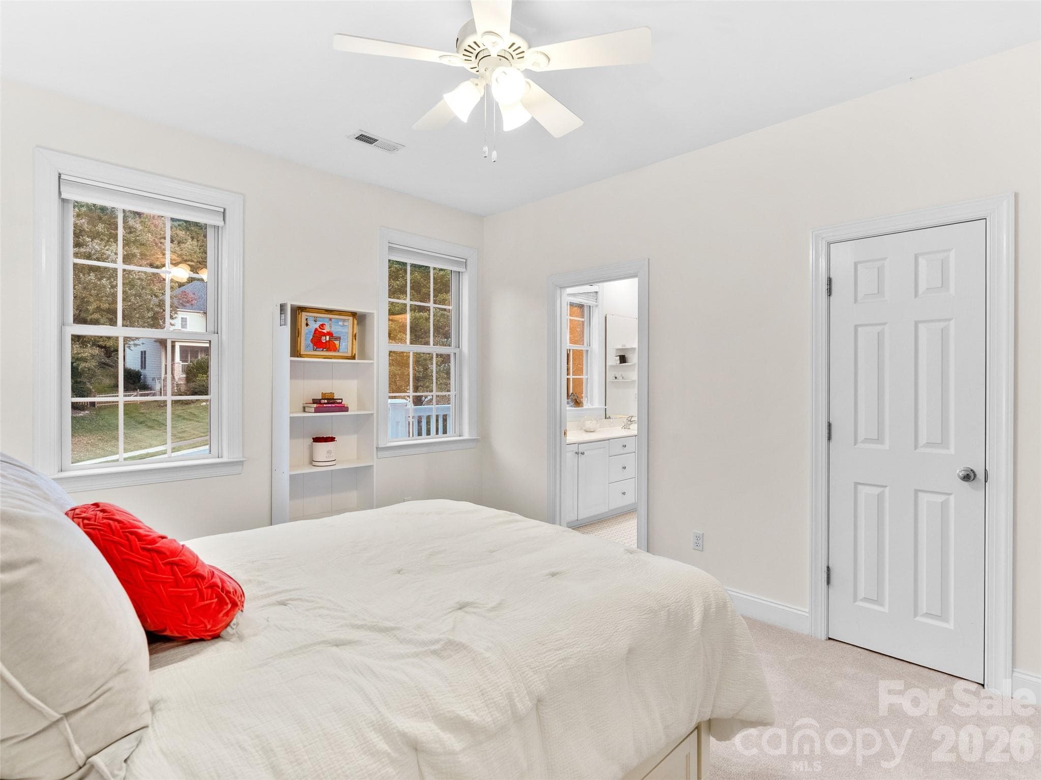 An upper-level bedroom with its own bathroom, ample windows, and closet space offers both functionality and a bright, inviting atmosphere. - Asheville