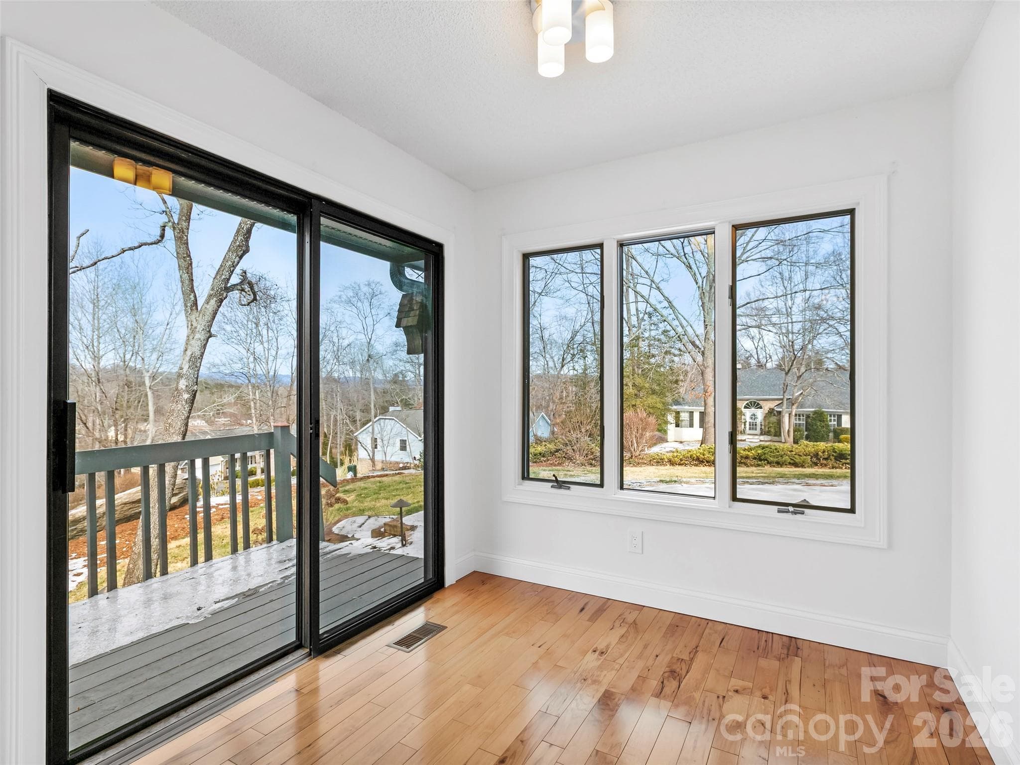 The bright breakfast area, just off the kitchen, offers beautiful mountain views and direct access to the deck, making it the perfect spot to enjoy your morning coffee. - 2731 Miller Lane, Hendersonville