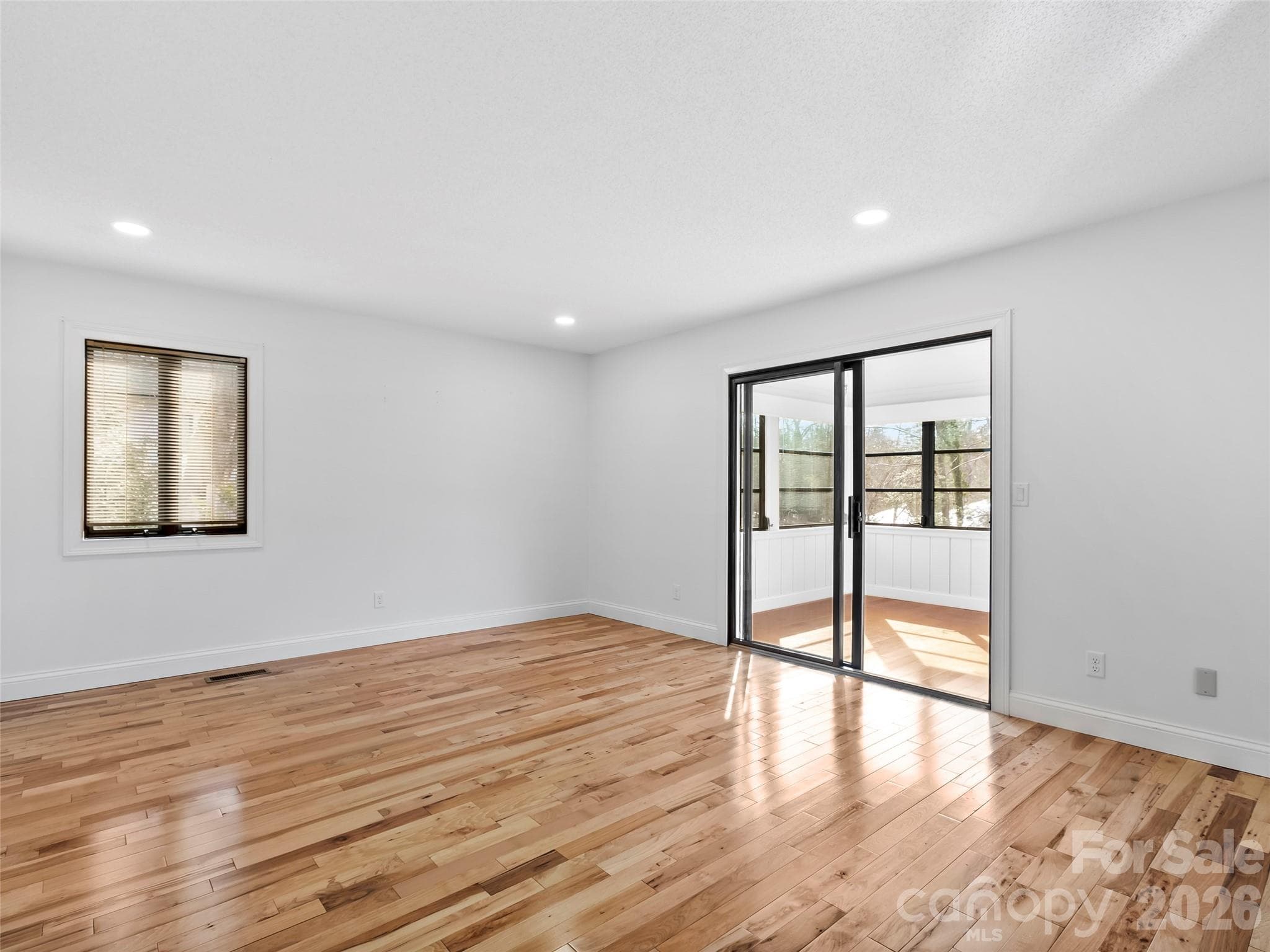 The spacious primary suite features private access to the all-season room, creating a peaceful retreat to enjoy year-round. - 2731 Miller Lane, Hendersonville