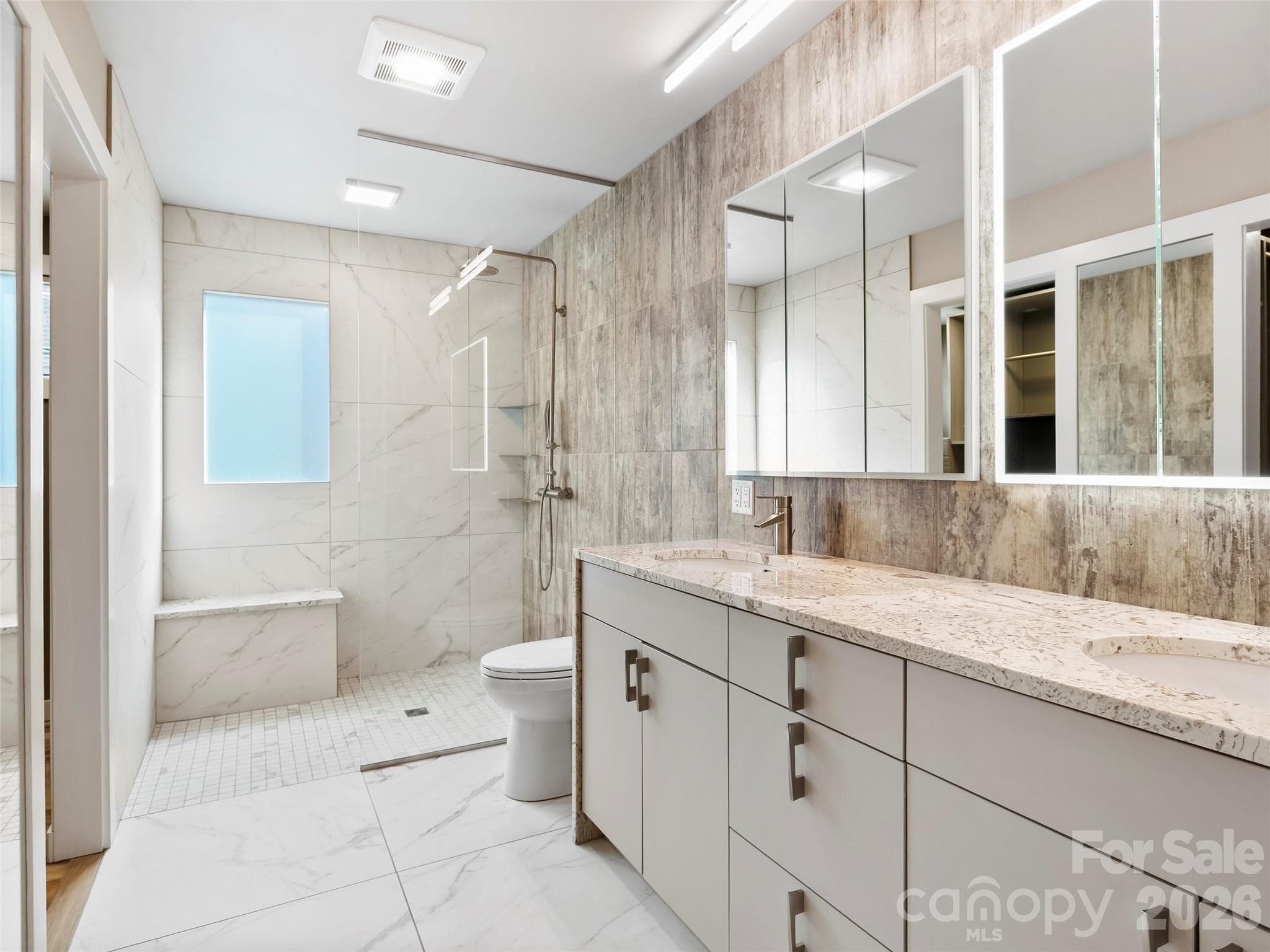 Beautifully updated primary bath featuring a zero-entry shower, modern finishes, and a spa-like feel. - 2731 Miller Lane, Hendersonville