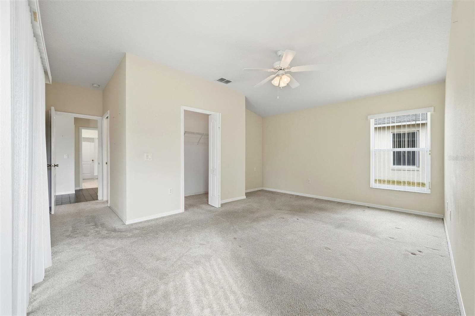 Primary Bedroom with walk-in closet and sliding doors to lanai - 2311 N ANDREA PT, LECANTO