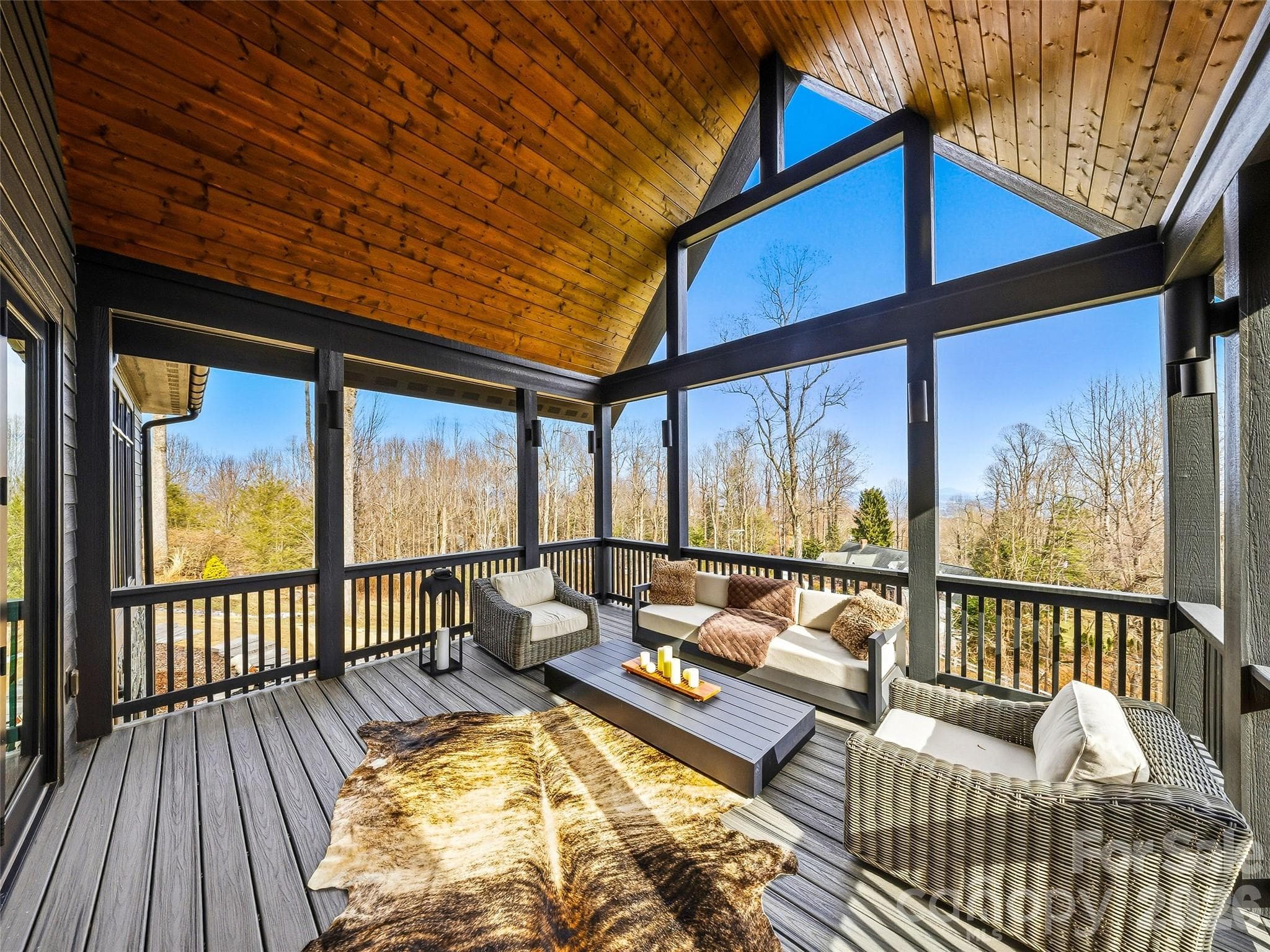 Spacious screened porch with seating area, panoramic windows, and warm wood finishes - 241 Tower Circle, Hendersonville