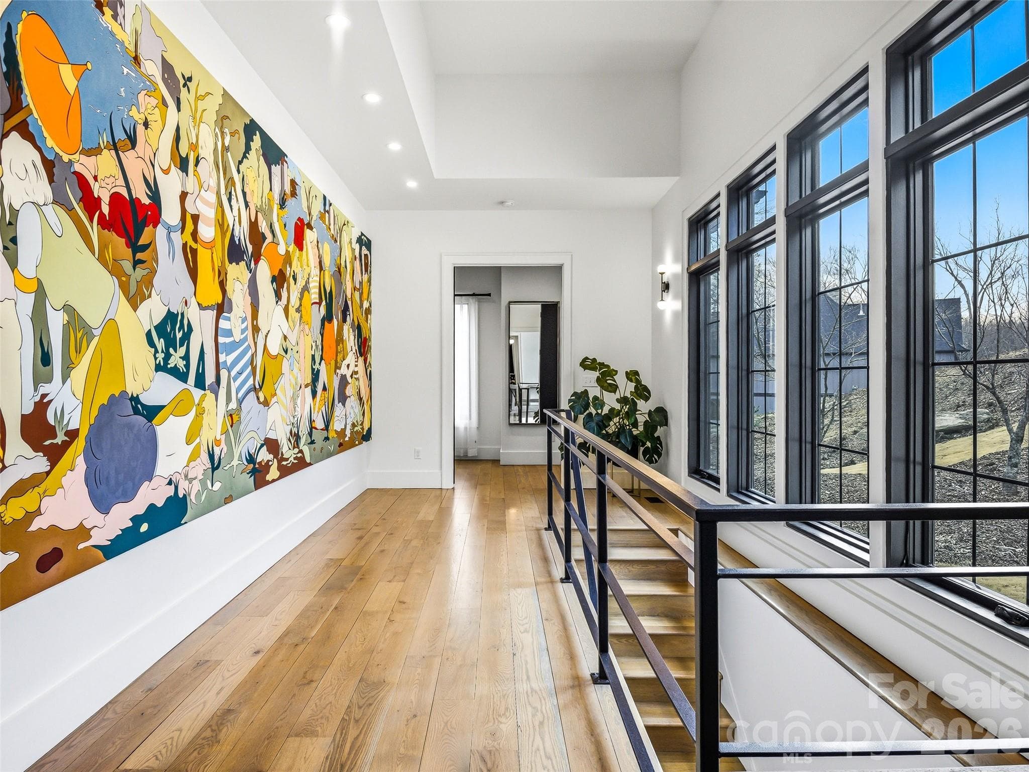 Upper hallway with oversized windows and modern railing leading to the primary suite - 241 Tower Circle, Hendersonville