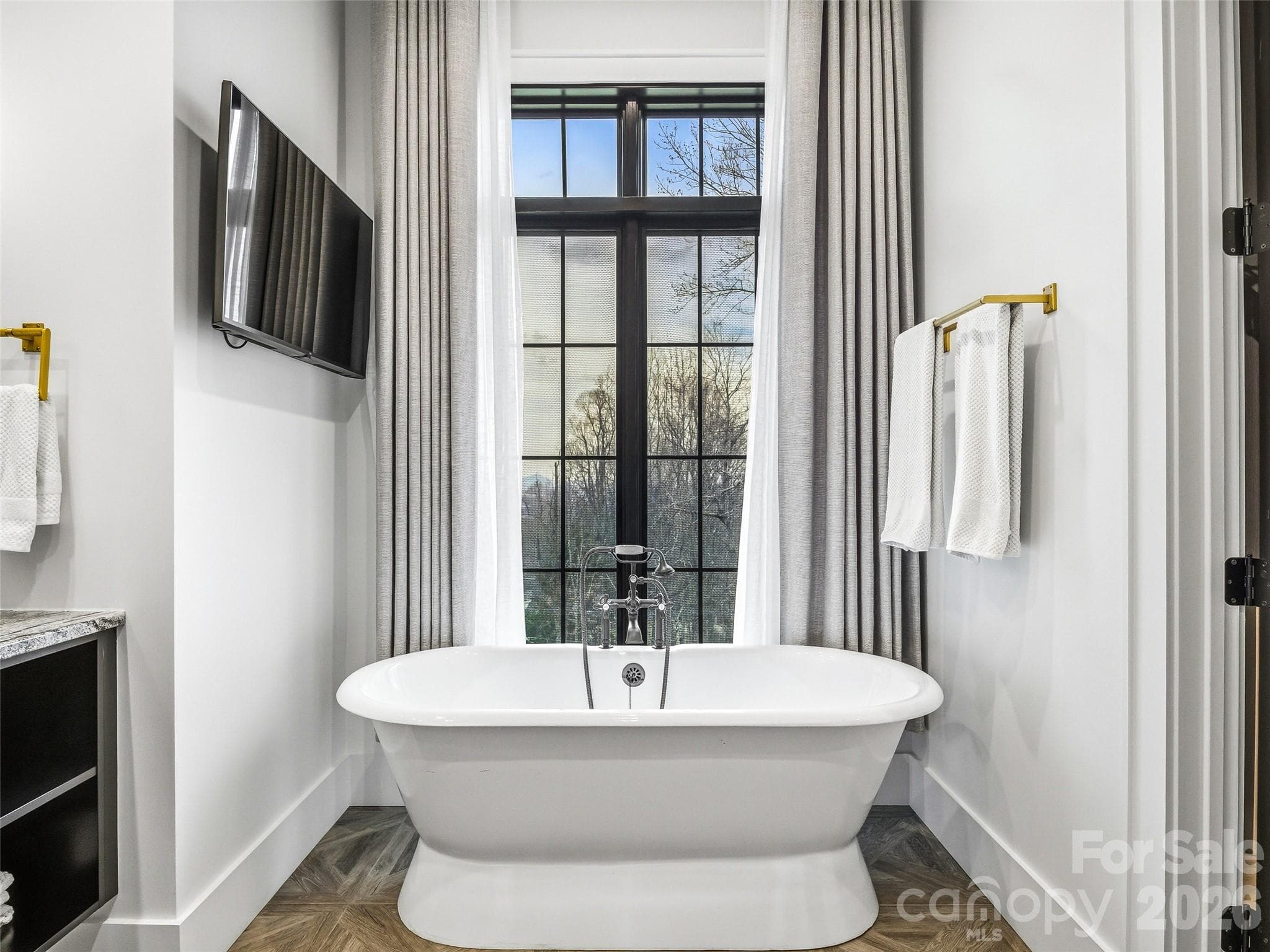 Freestanding soaking tub positioned beneath large windows for a bright, spa-like retreat - 241 Tower Circle, Hendersonville