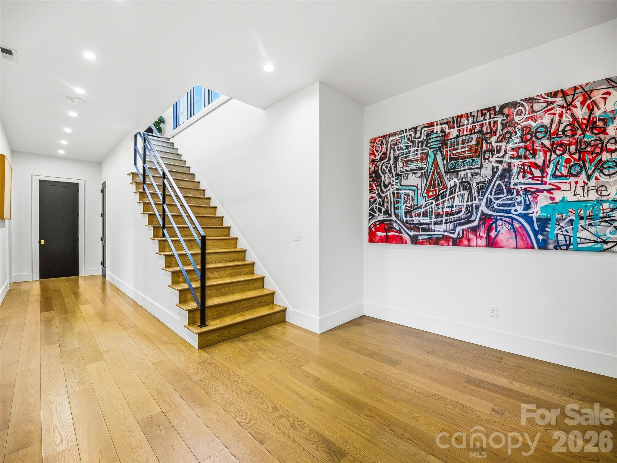 Lower-level entry with hardwood floors, modern staircase, and clean architectural lines - 241 Tower Circle, Hendersonville