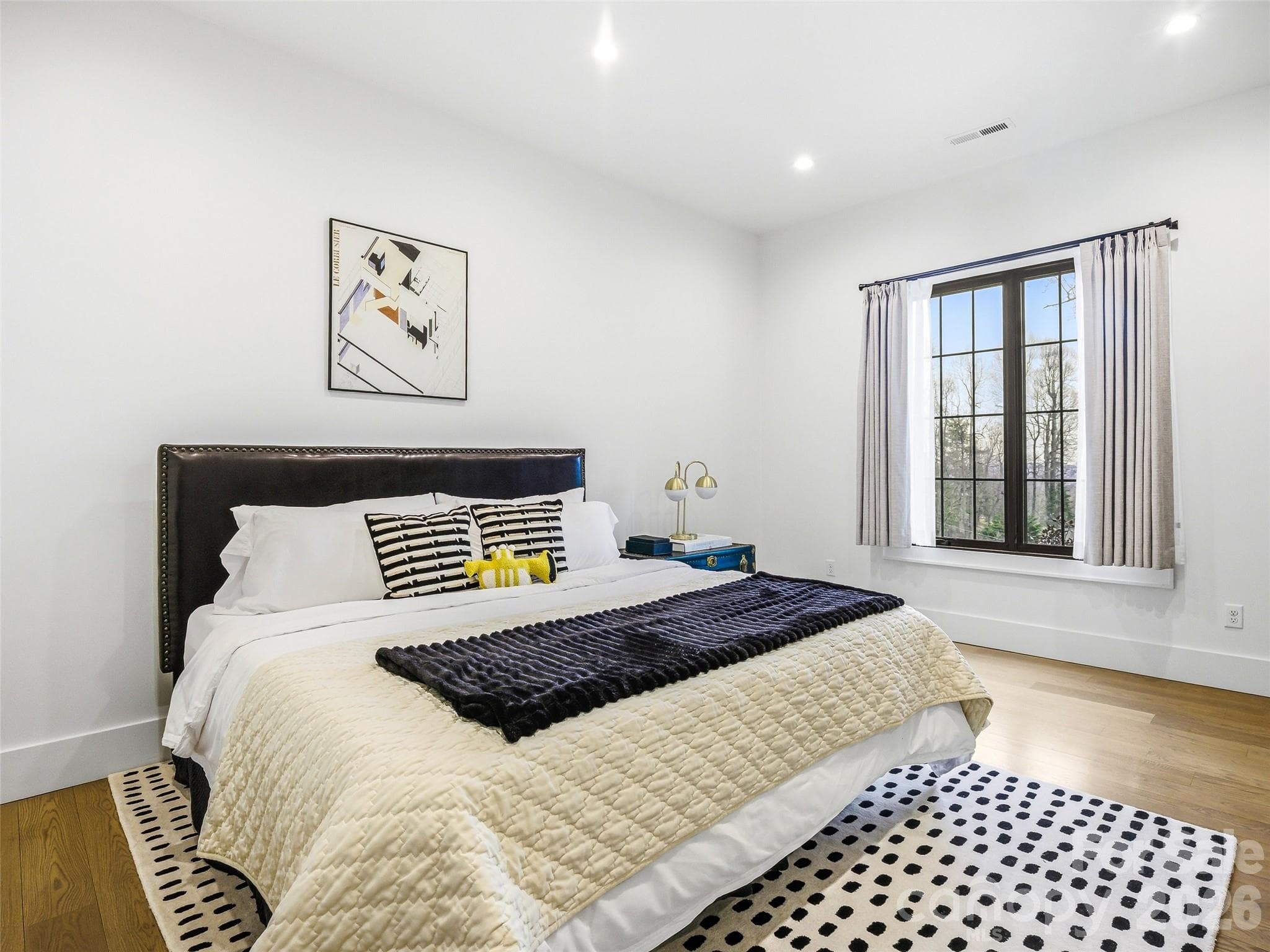 Lower-level guest bedroom with hardwood floors and natural light - 241 Tower Circle, Hendersonville