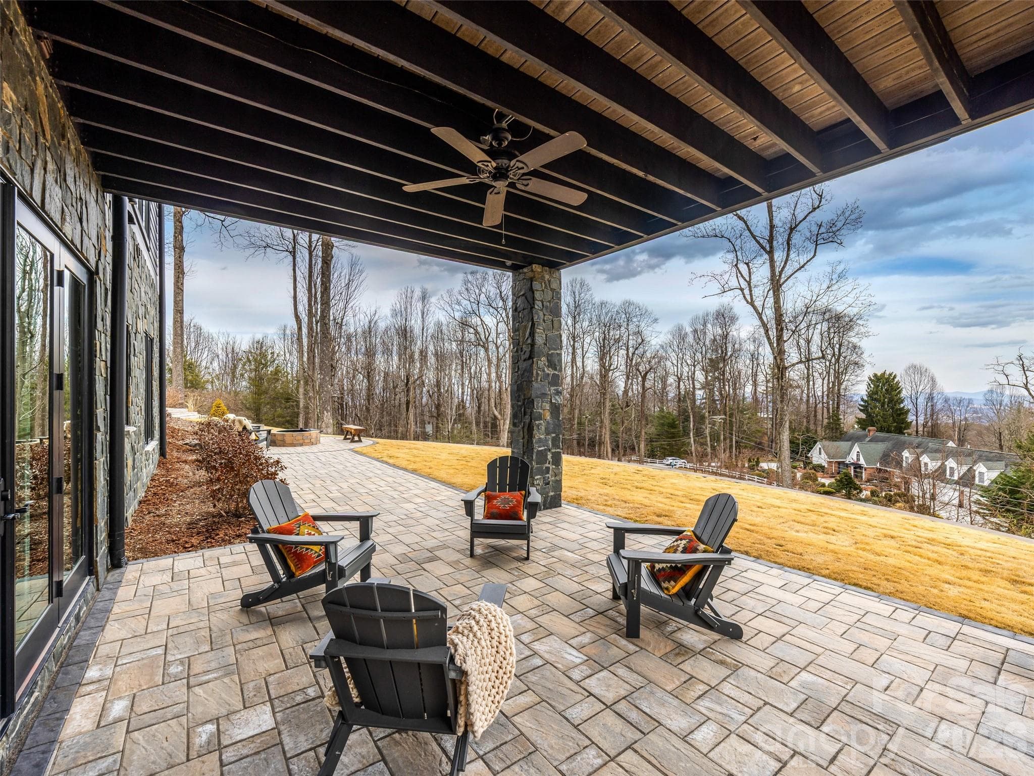 Covered lower patio with stone flooring and ceiling detail for shaded outdoor living - 241 Tower Circle, Hendersonville