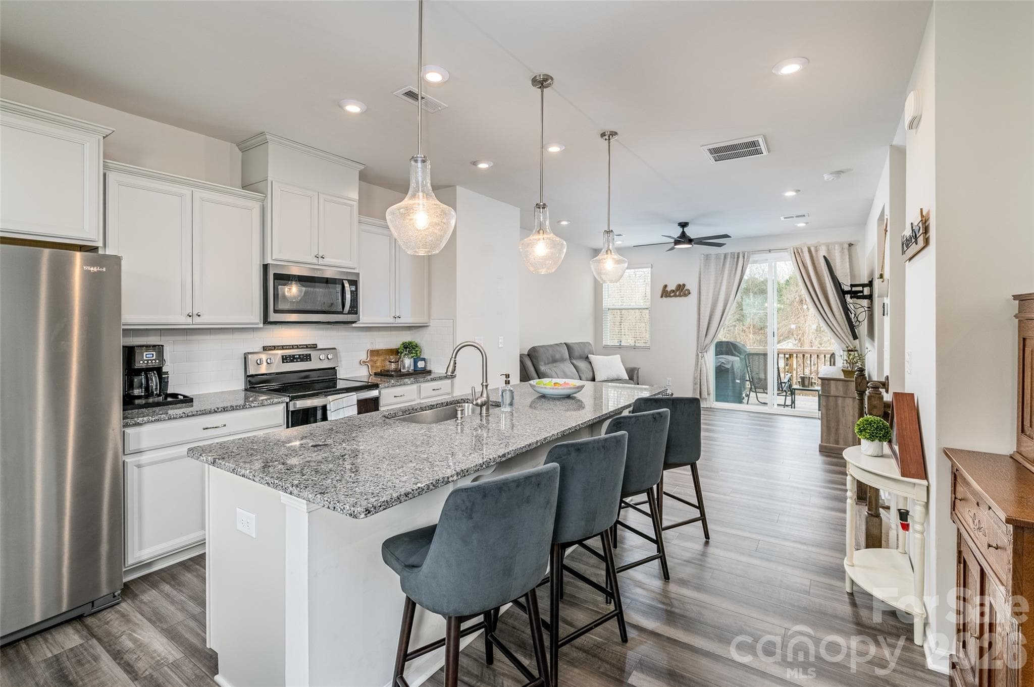 Upgraded kitchen features granite counters, stainless steel appliances, tile back splash, spacious island with seating & storage, pantry & dining area on middle level floor. - 1206 Keydet Drive, Charlotte