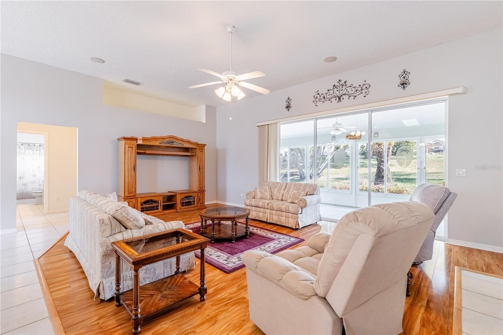 Great room with three panel hide-a-way sliders into Florida room. - 5732 FREEPORT DR, TAVARES
