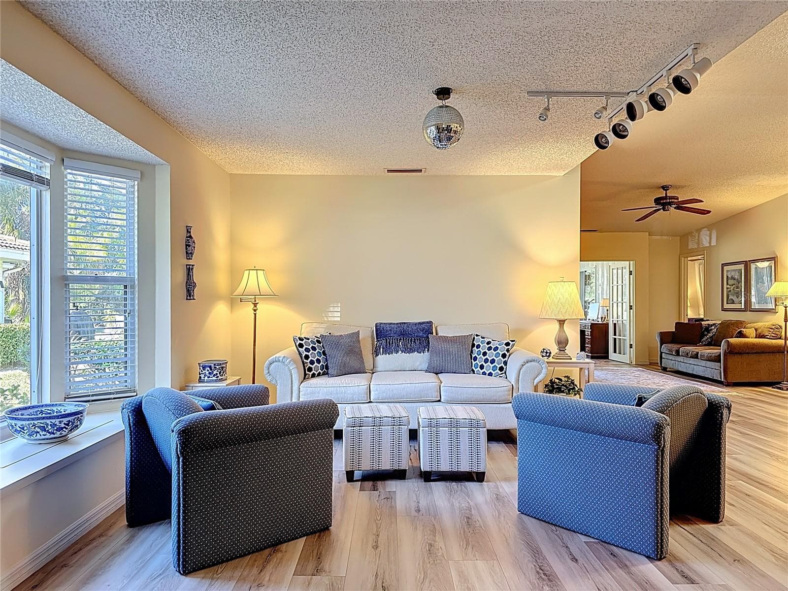 Living room with bay window and track lighting. The bay window has a bench seat and storage area. - 5611 GARDEN LAKES DR, BRADENTON