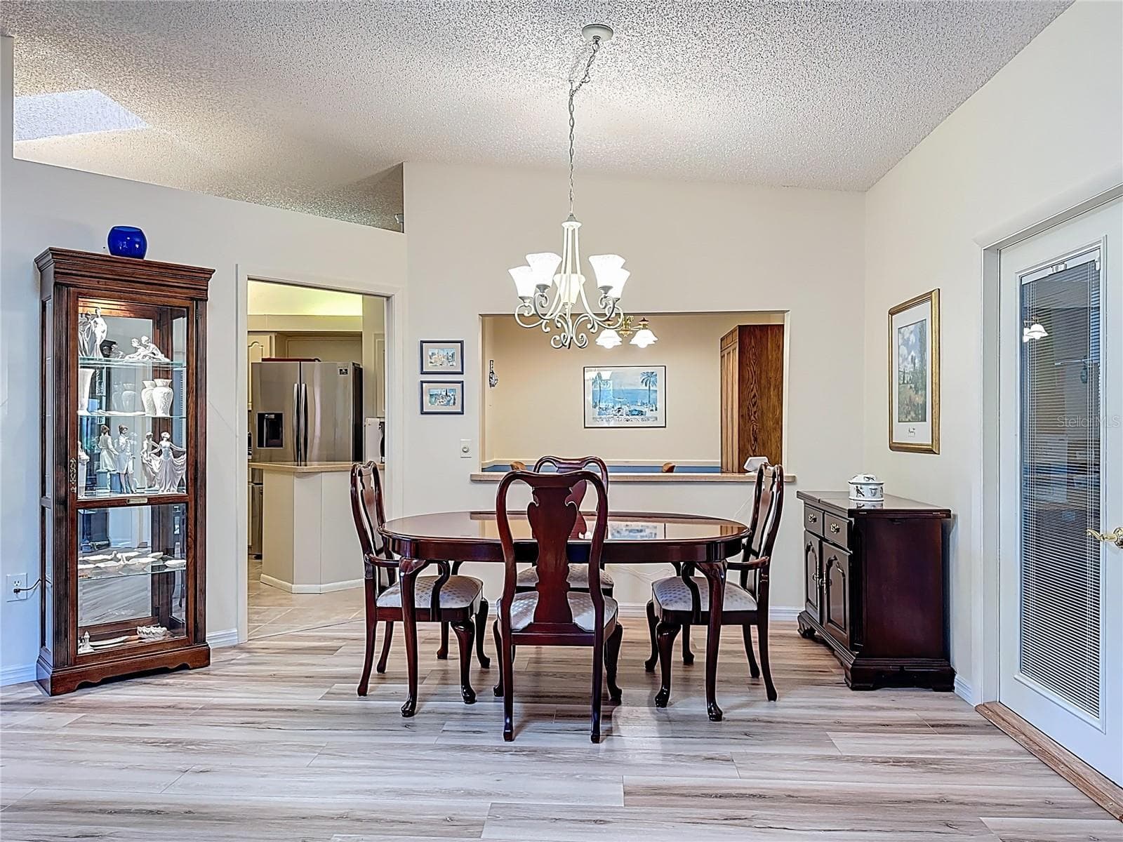 Dining room with pass through to the eat in kitchen area. French doors on the right lead into the garage that offers a ramp for wheelchair accessibility or those large moving items. - 5611 GARDEN LAKES DR, BRADENTON