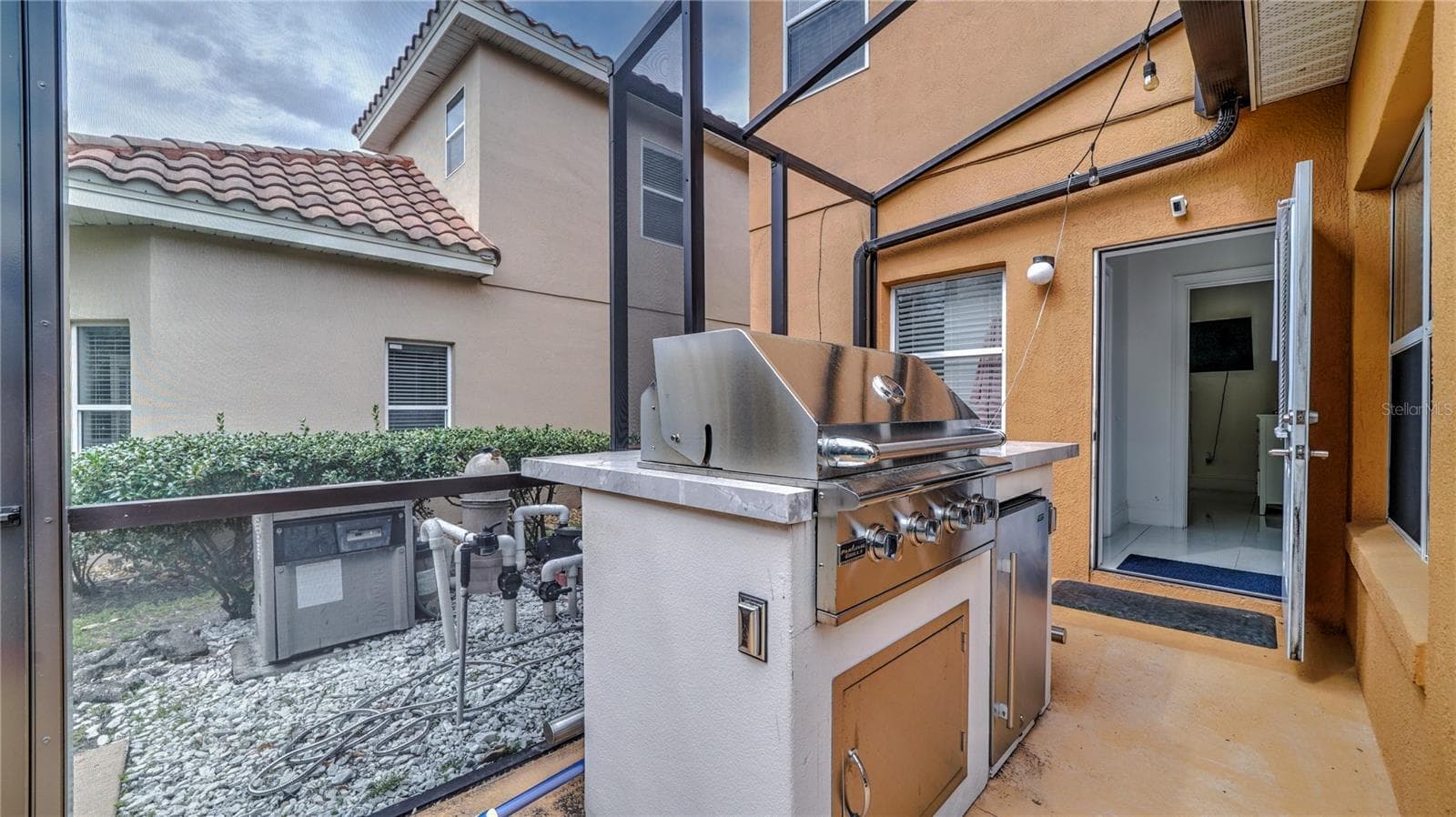Screened lanai featuring a built-in stainless steel grill. - 6956 LUCCA ST, ORLANDO