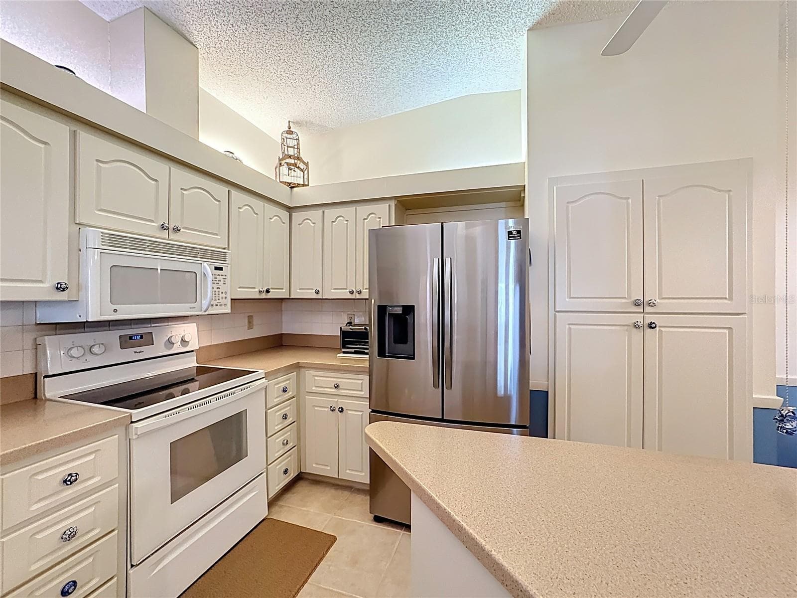 Newer refrigerator 2024. Convenience of an island counter and pantry with roll out shelves. - 5611 GARDEN LAKES DR, BRADENTON