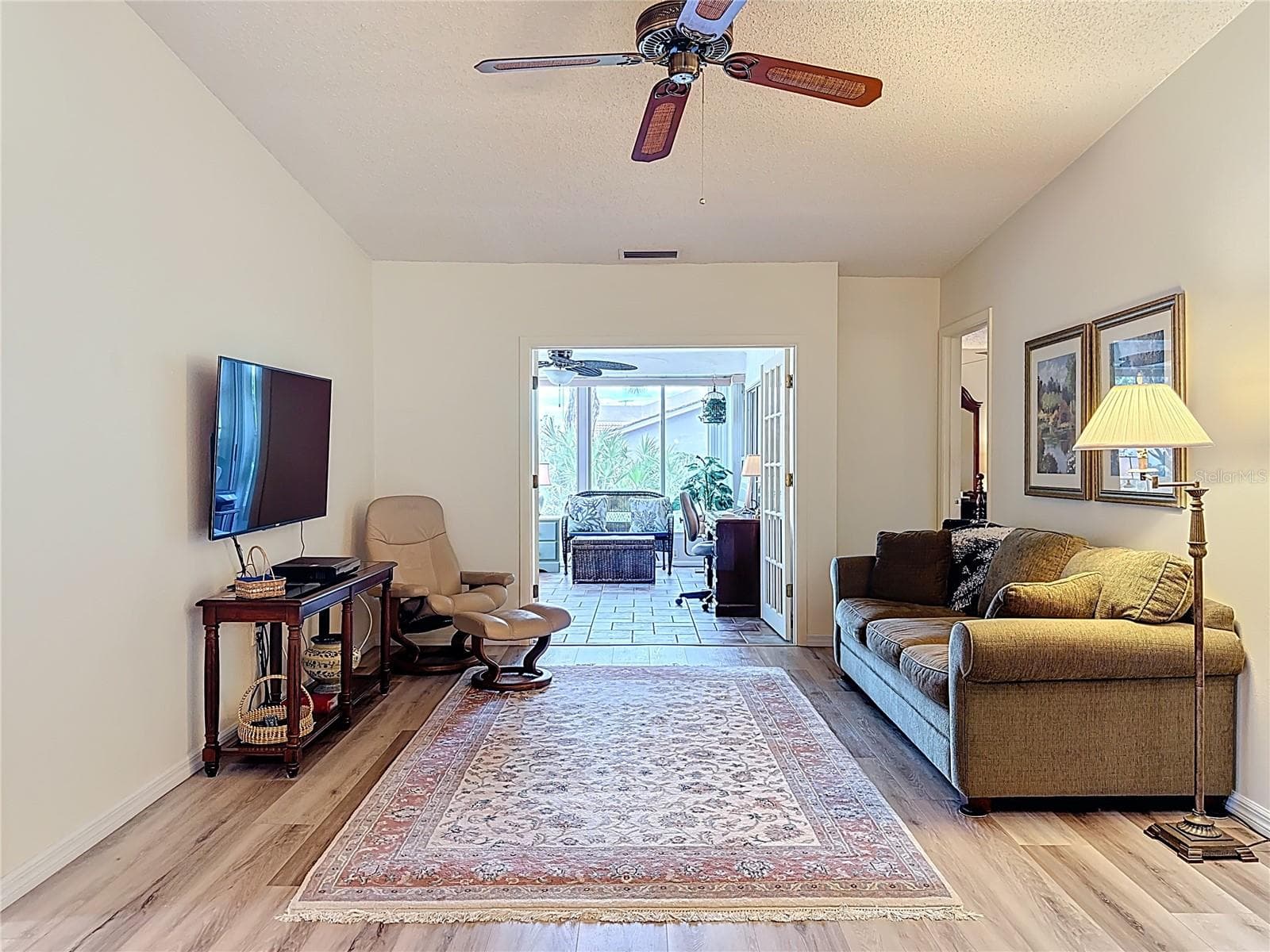 Family room with French doors leading into Florida Room. - 5611 GARDEN LAKES DR, BRADENTON