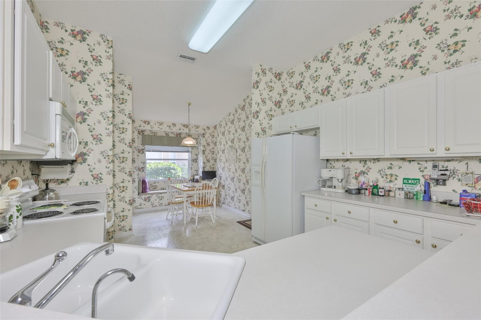 KITCHEN OPENS INTO THE GREAT ROOM. LOADS OF CABINET AND COUNTER SPACE. - 2308 BROOKFIELD GREENS CIR, SUN CITY CENTER