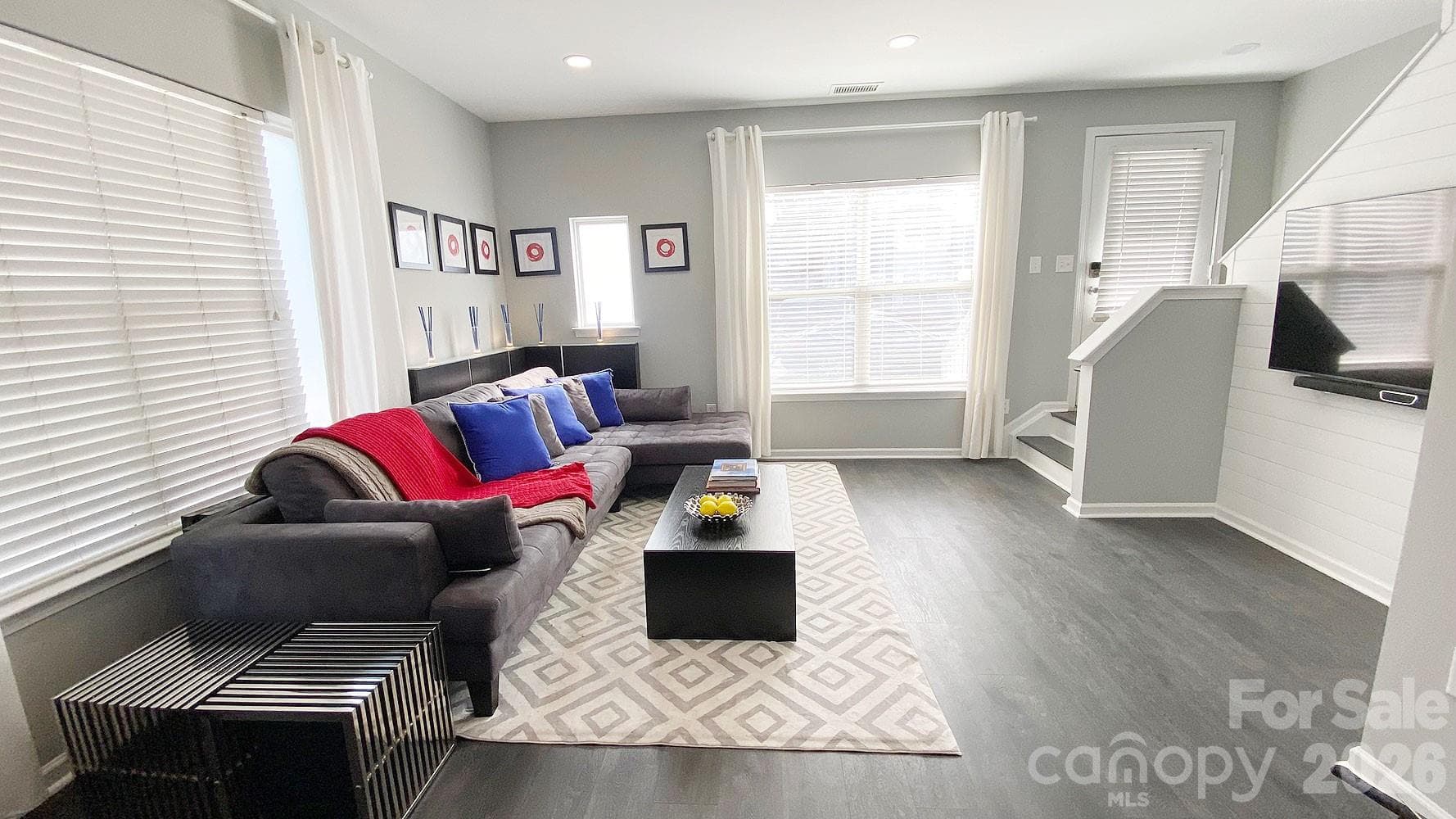 Living area has waterproof LVP flooring (throughout townhouse) and shiplap tv wall. There are 6 recessed LED lights on a dimmer for the perfect light setting - Charlotte