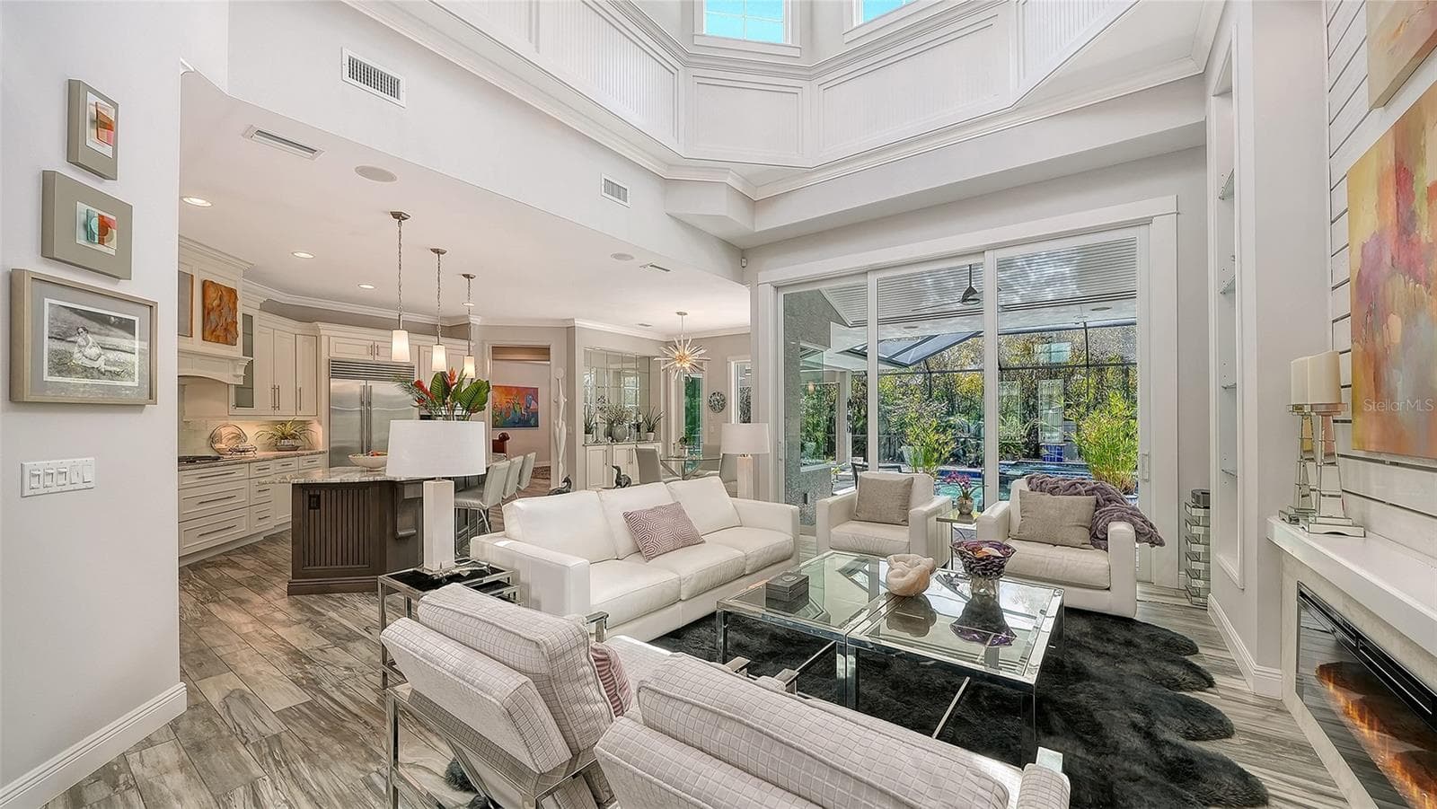 An electric fireplace, 21' ceilings, and a coffered ceiling are highlights of the Great Room - 1794 CUNLIFF LN, SARASOTA