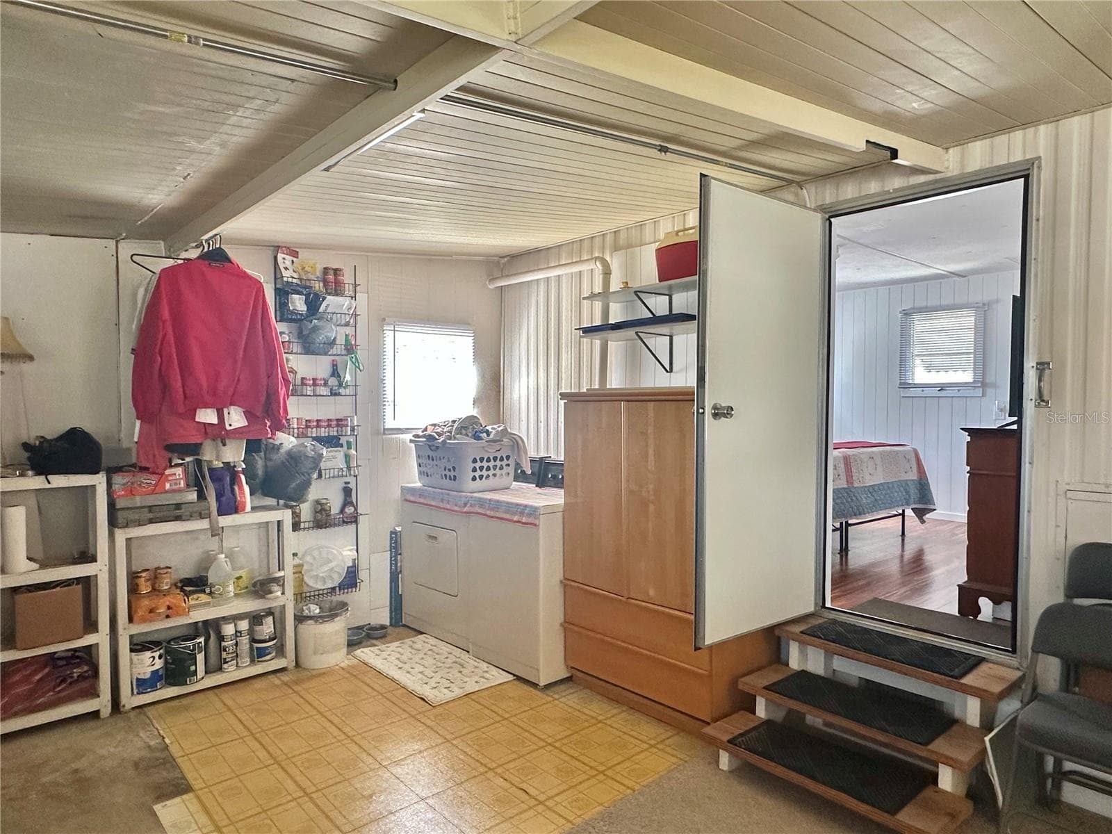 entrance down into enclosed porch area which provides a laundry area, extra storage as well as another sleeping area. This room is under AC & heat too! - 1501 25TH AVENUE DR W, BRADENTON