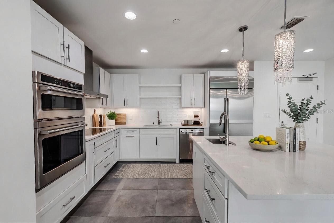 This sophisticated, all-white kitchen exudes modern elegance with its clean lines and luxury finishes. - 920 N OSCEOLA AVE #703, CLEARWATER