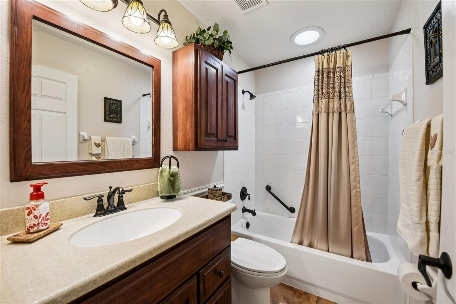 Guest bath with wood cabinets and Corian counter tops, Ceramic tile floors. - 6105 DORY WAY, TAVARES