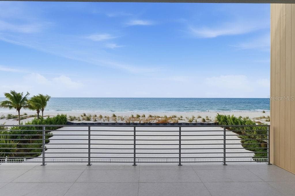 Main floor terrace highlights 40 feet of outdoor living space featuring Longboard™ accents to compliment to azure blue Gulf - 6489 GULFSIDE RD, LONGBOAT KEY