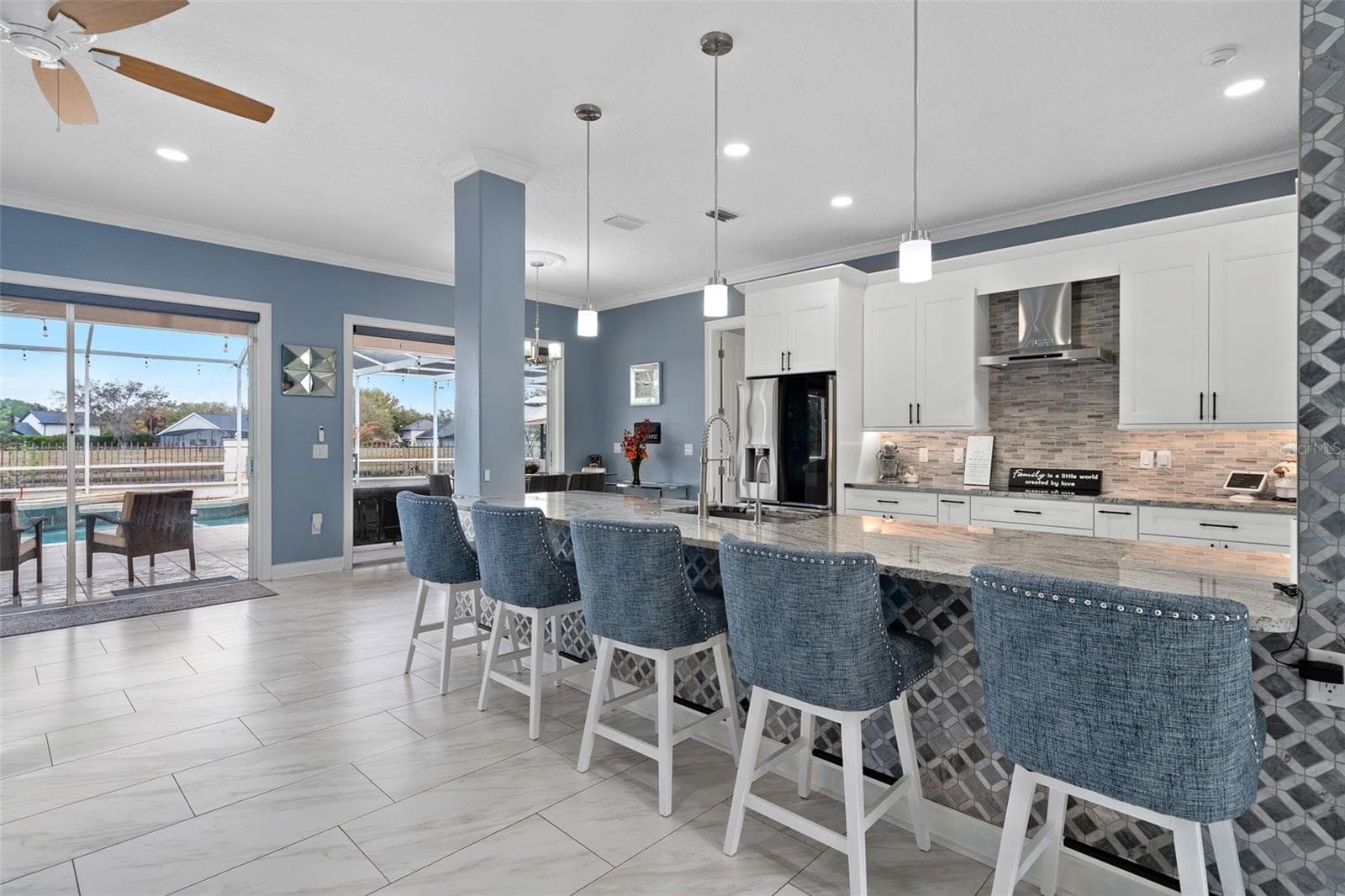 Kitchen has custom backsplash and a stone accent wall. This Chefs kitchen has been completely remodeled with new white shaker cabinets, a large breakfast bar, built in oven and microwave and granite countertops. - 9057 BALMORAL MEWS SQ, WINDERMERE