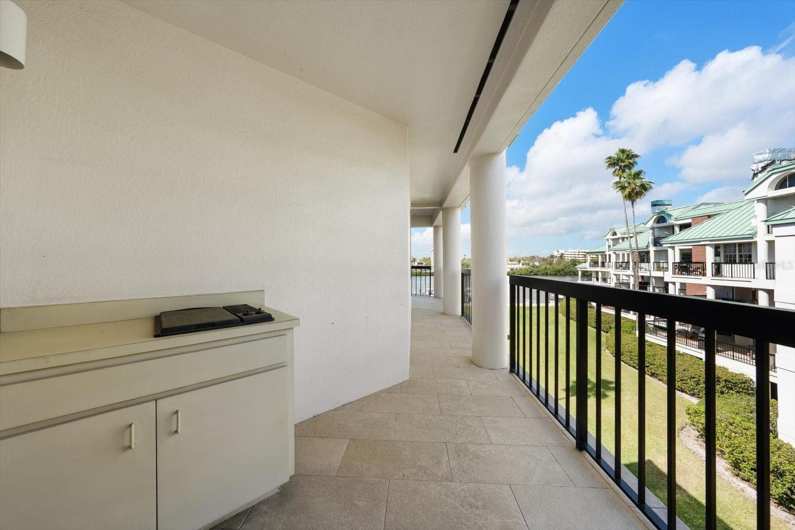 Wraparound balcony continues toward water, with kitchen and living room access beyond background. - 947 SEDDON COVE WAY #947, TAMPA