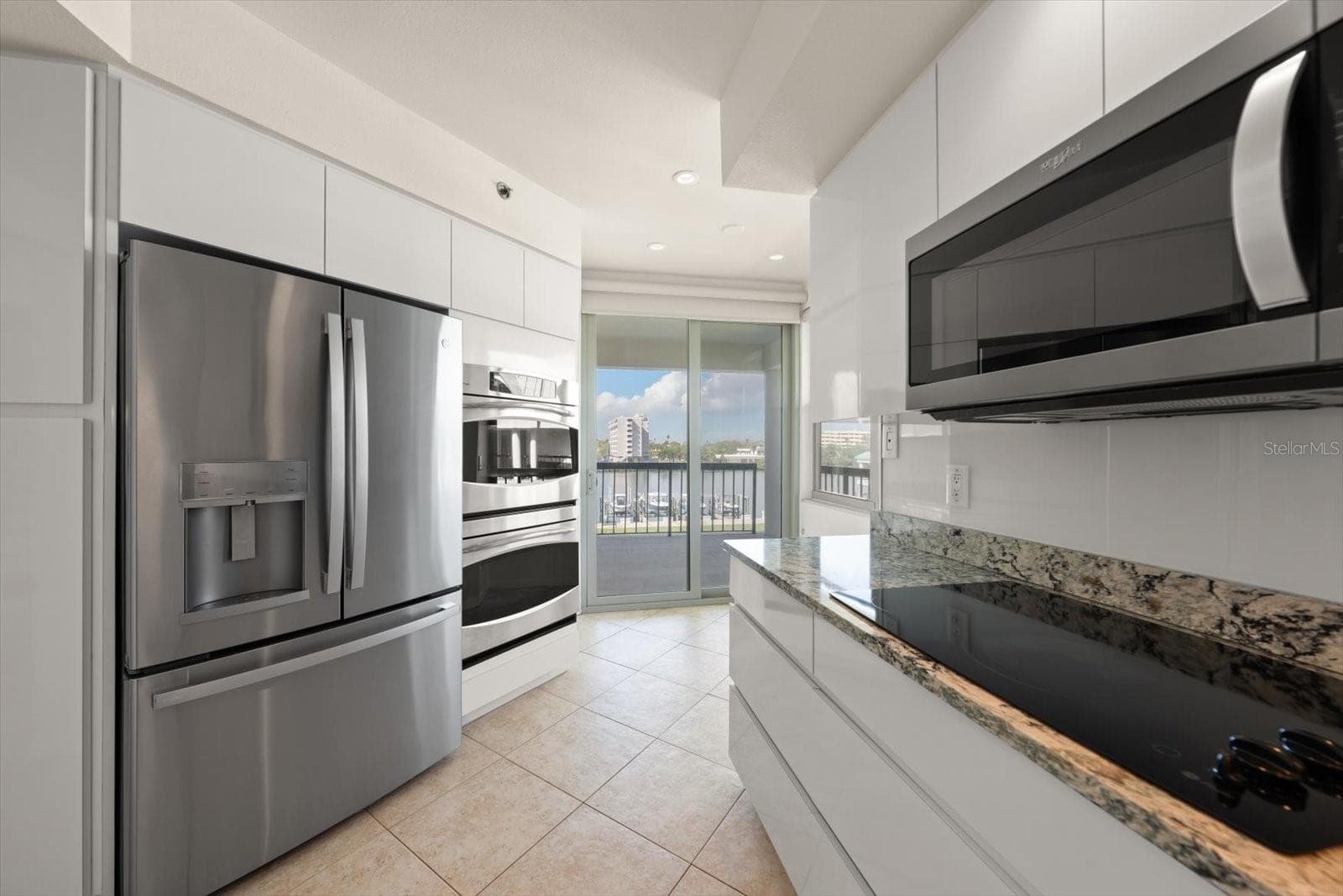 Kitchen with water views. Excellent cabinet space with deep drawers, newer stainless steel appliances including double ovens. Access to balcony from sliding glass door. - 947 SEDDON COVE WAY #947, TAMPA